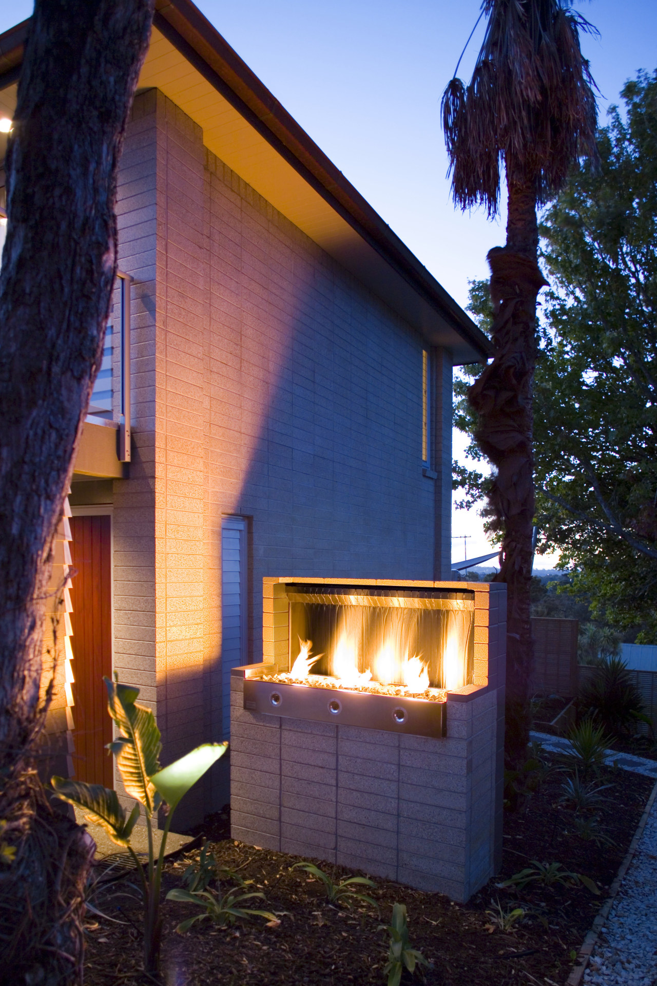 view of outdoor fireplace from Real Fires. architecture, backyard, cottage, facade, home, house, lighting, property, real estate, residential area, shed, siding, window, wood, blue