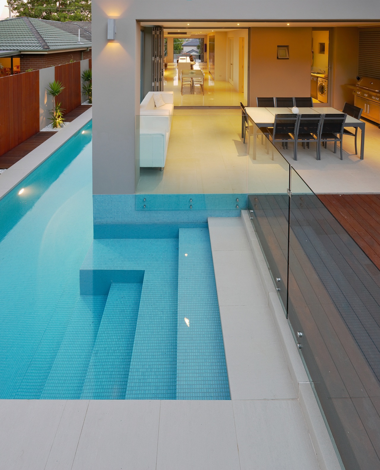 Pool runs alongside living room in contemporary home composite material, daylighting, floor, flooring, hardwood, leisure, leisure centre, property, real estate, swimming pool, tile, wood, wood flooring, gray, teal