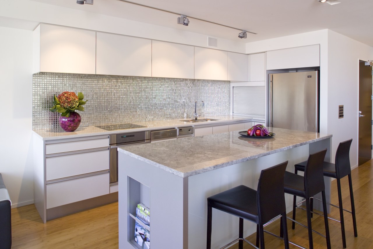 View of kitchen featuring wall tiling, kitchen island, cabinetry, countertop, floor, flooring, interior design, kitchen, real estate, room, gray