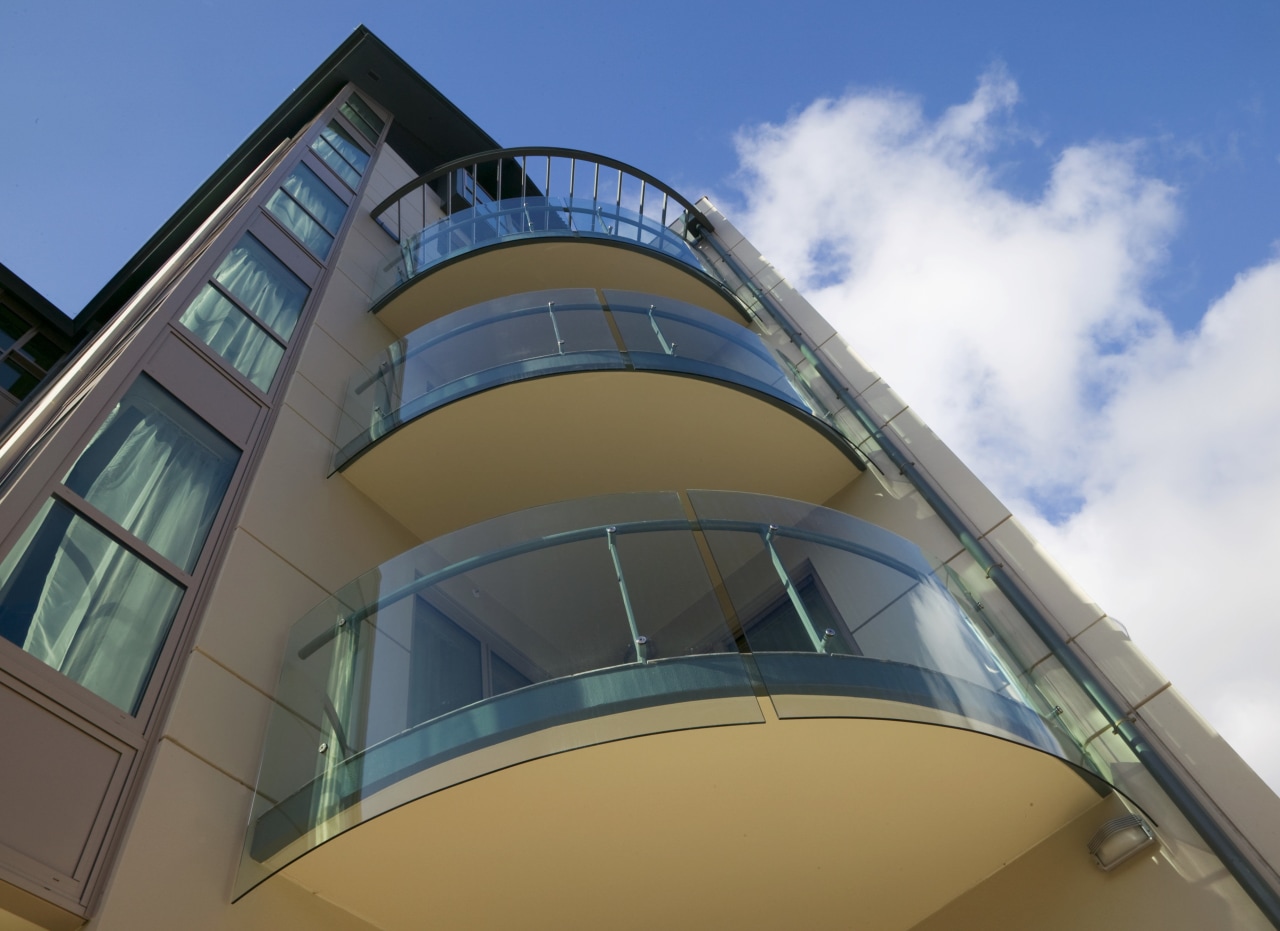 Curved glass balustrades help to maximise views from architecture, building, commercial building, daylighting, daytime, facade, glass, sky, structure, teal