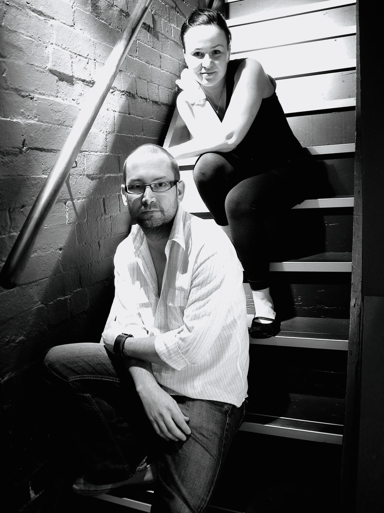 Kitchen designers Darren Genner and Simona Castagna with black, black and white, fun, gentleman, girl, man, monochrome, monochrome photography, muscle, photo shoot, photograph, photography, sitting, snapshot, standing, white, black