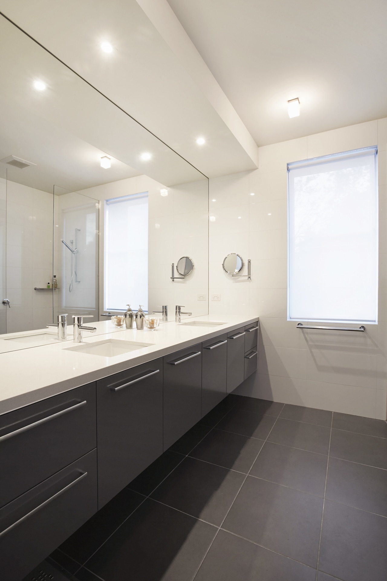 Bathrooms are designed in cool neutrals, with dark architecture, bathroom, ceiling, countertop, daylighting, floor, home, interior design, real estate, room, sink, tile, white