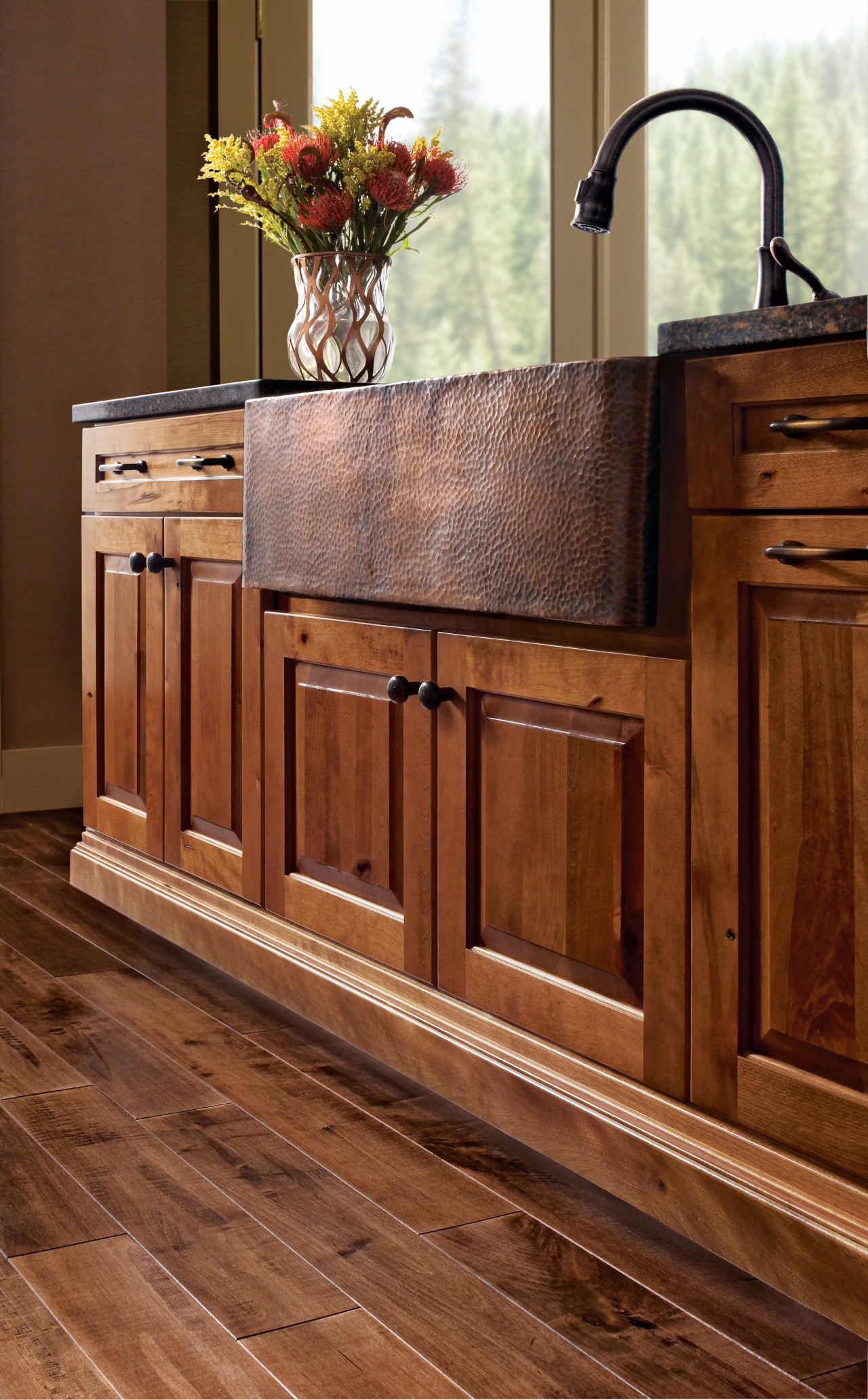 View of a kitchen which features wooden cabinetry cabinetry, chest of drawers, countertop, drawer, floor, flooring, furniture, hardwood, laminate flooring, sideboard, tile, wood, wood flooring, wood stain, brown