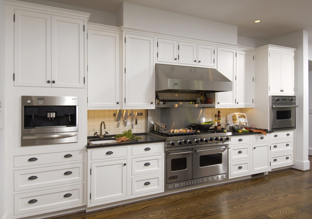 View of kitchen with white painted maple cabinetry, cabinetry, countertop, cuisine classique, floor, flooring, home appliance, kitchen, kitchen appliance, kitchen stove, room, gray