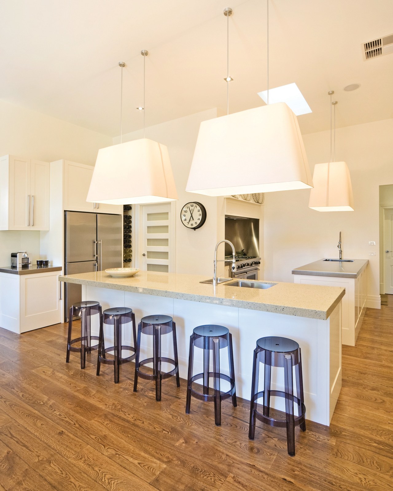 View of a kitchen featuring long island with ceiling, chair, countertop, dining room, floor, flooring, furniture, hardwood, home, interior design, kitchen, laminate flooring, light fixture, product design, room, table, wood flooring, orange