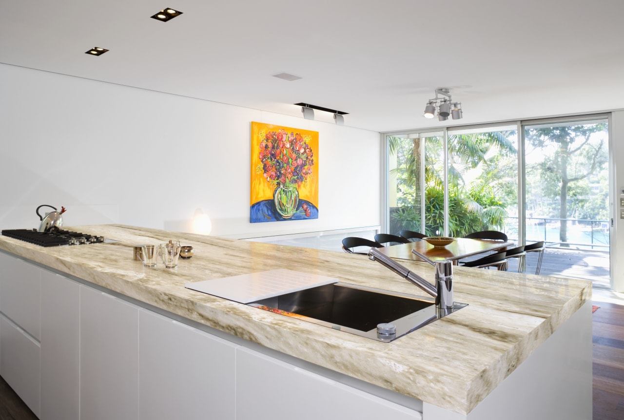 View of a kitchen island topped with a countertop, floor, interior design, kitchen, real estate, room, sink, gray