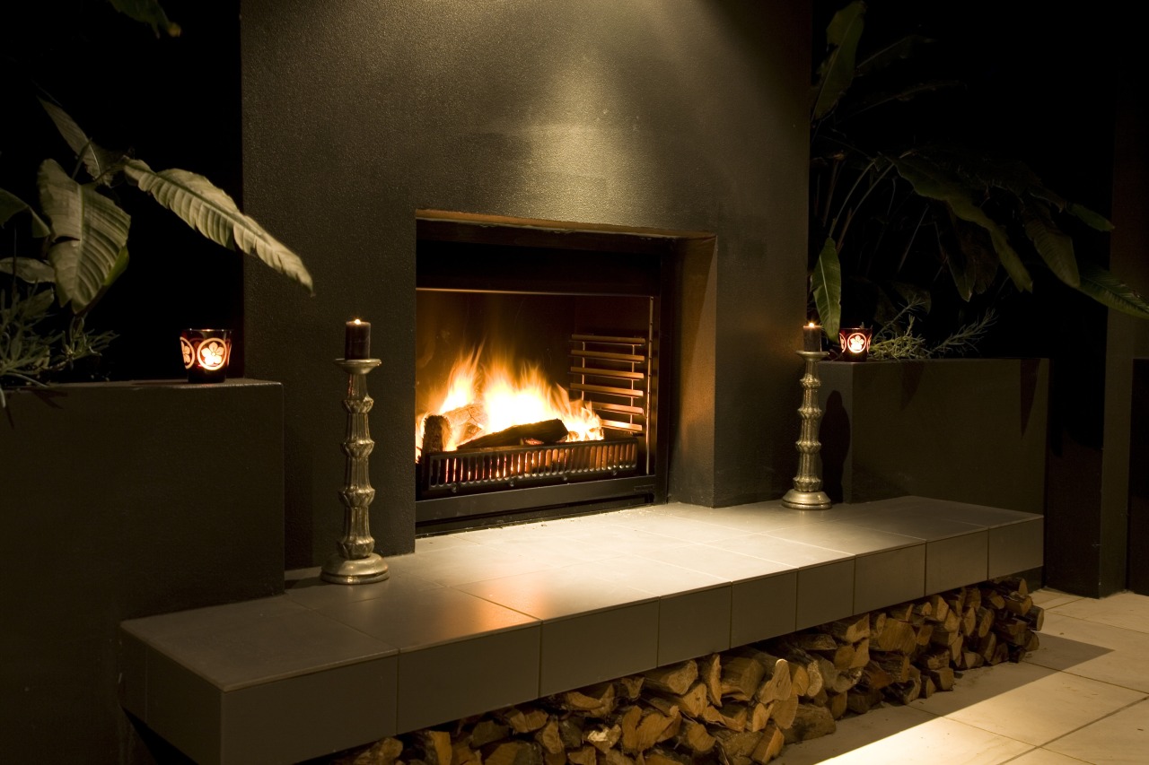 View of an outdoor entertaining area which features fireplace, hearth, heat, brown, black