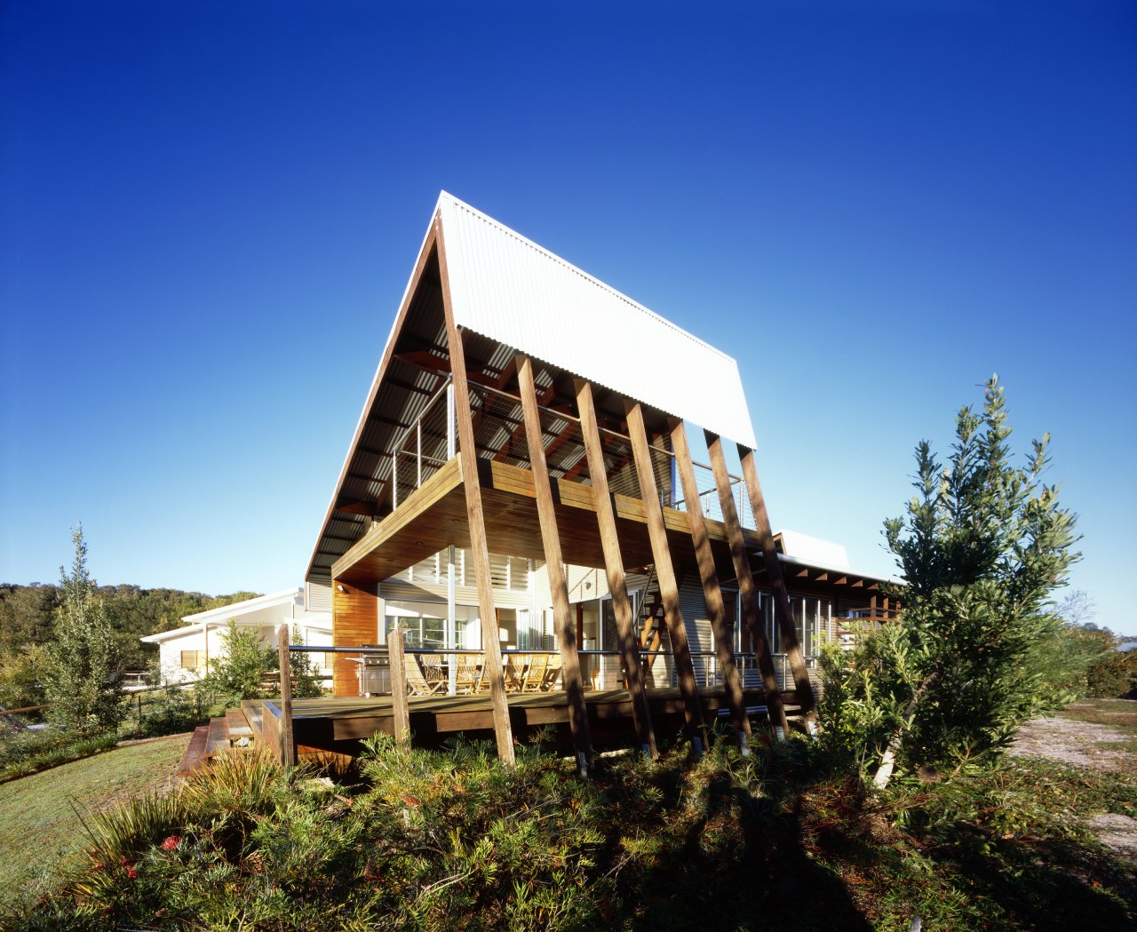 Exterior view of a canal-side beach house which architecture, cottage, estate, farmhouse, home, house, property, real estate, sky, blue