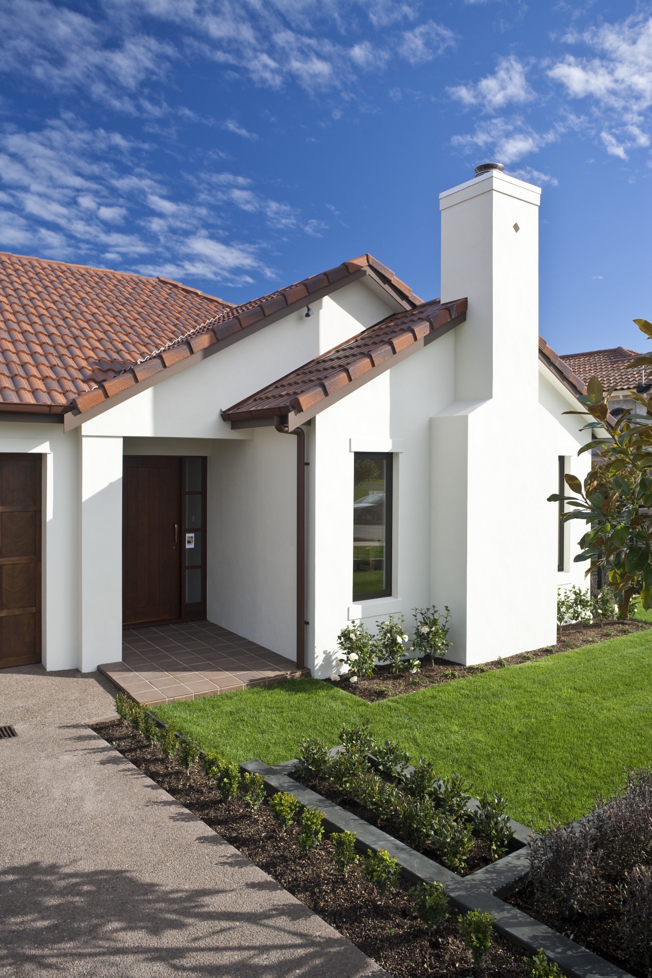 Exterior view of home featuring brick cladding, doors architecture, building, cottage, estate, facade, hacienda, home, house, property, real estate, residential area, roof, sky, villa, gray