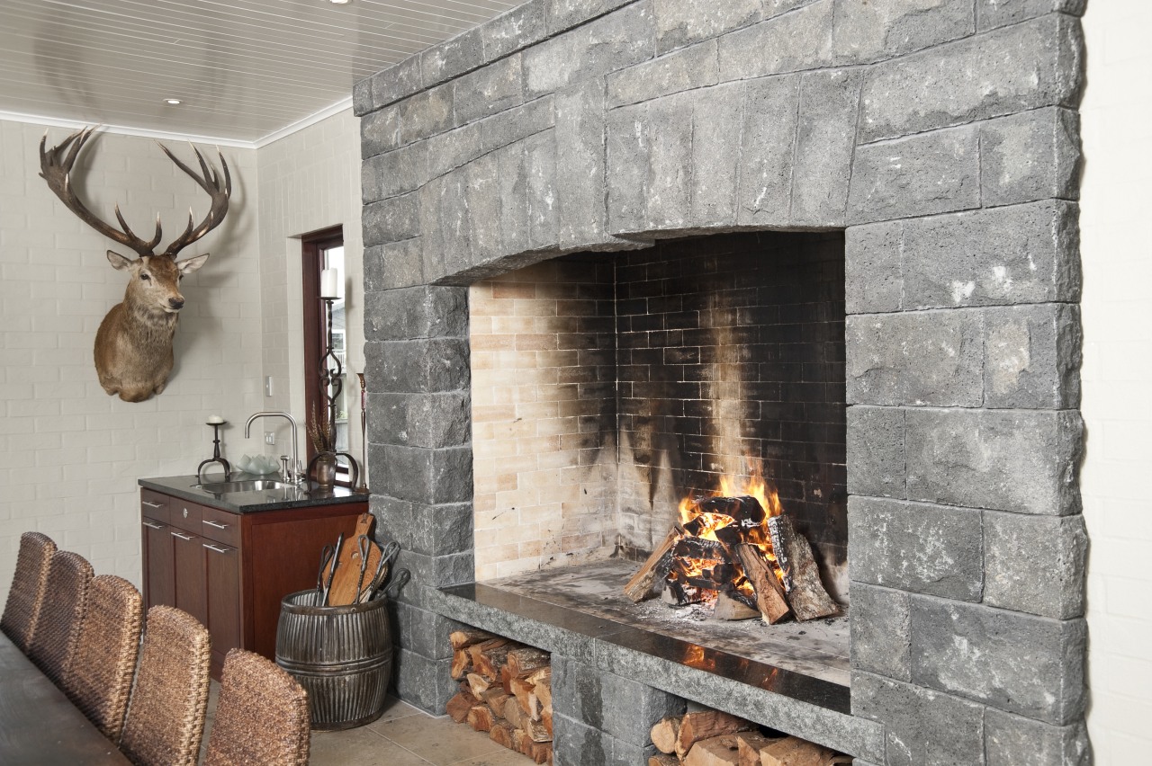 In the dining area of the home this fireplace, hearth, interior design, wood burning stove, gray