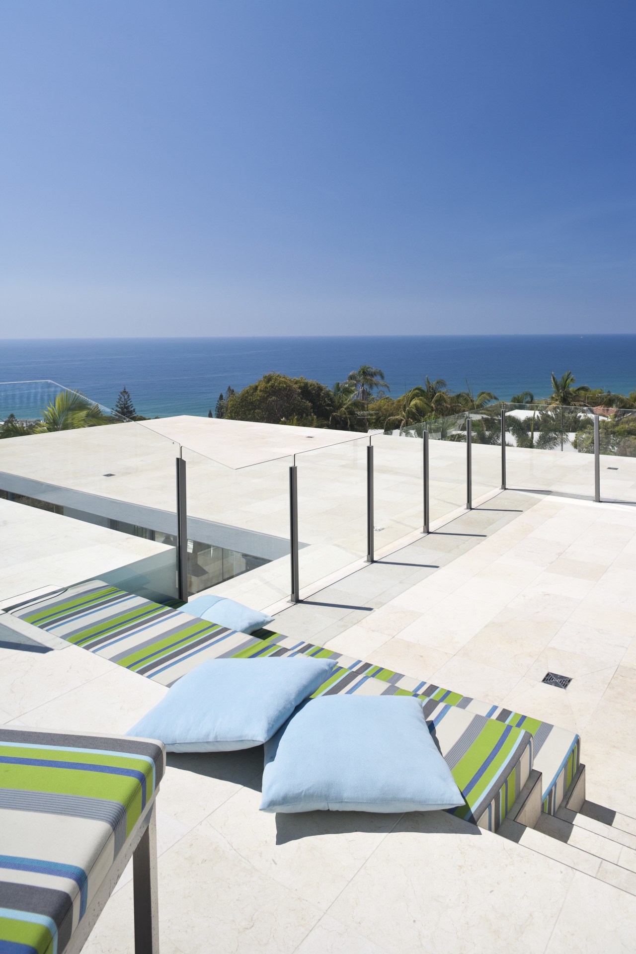 View of rooftop terrace which features paving, outdoor beach, condominium, estate, ocean, outdoor furniture, property, real estate, resort, sea, sky, sunlounger, vacation, teal, white