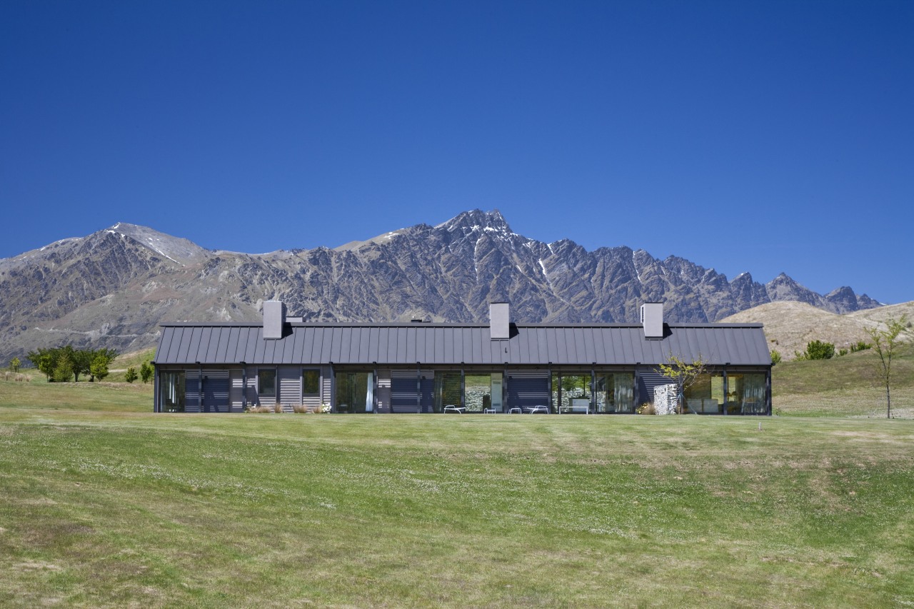 Exterior view of a country home which features alps, barn, cottage, elevation, estate, farm, farmhouse, field, grass, grassland, highland, home, house, hut, land lot, landscape, meadow, mount scenery, mountain, mountain range, mountainous landforms, national park, pasture, property, ranch, real estate, roof, rural area, sky, blue
