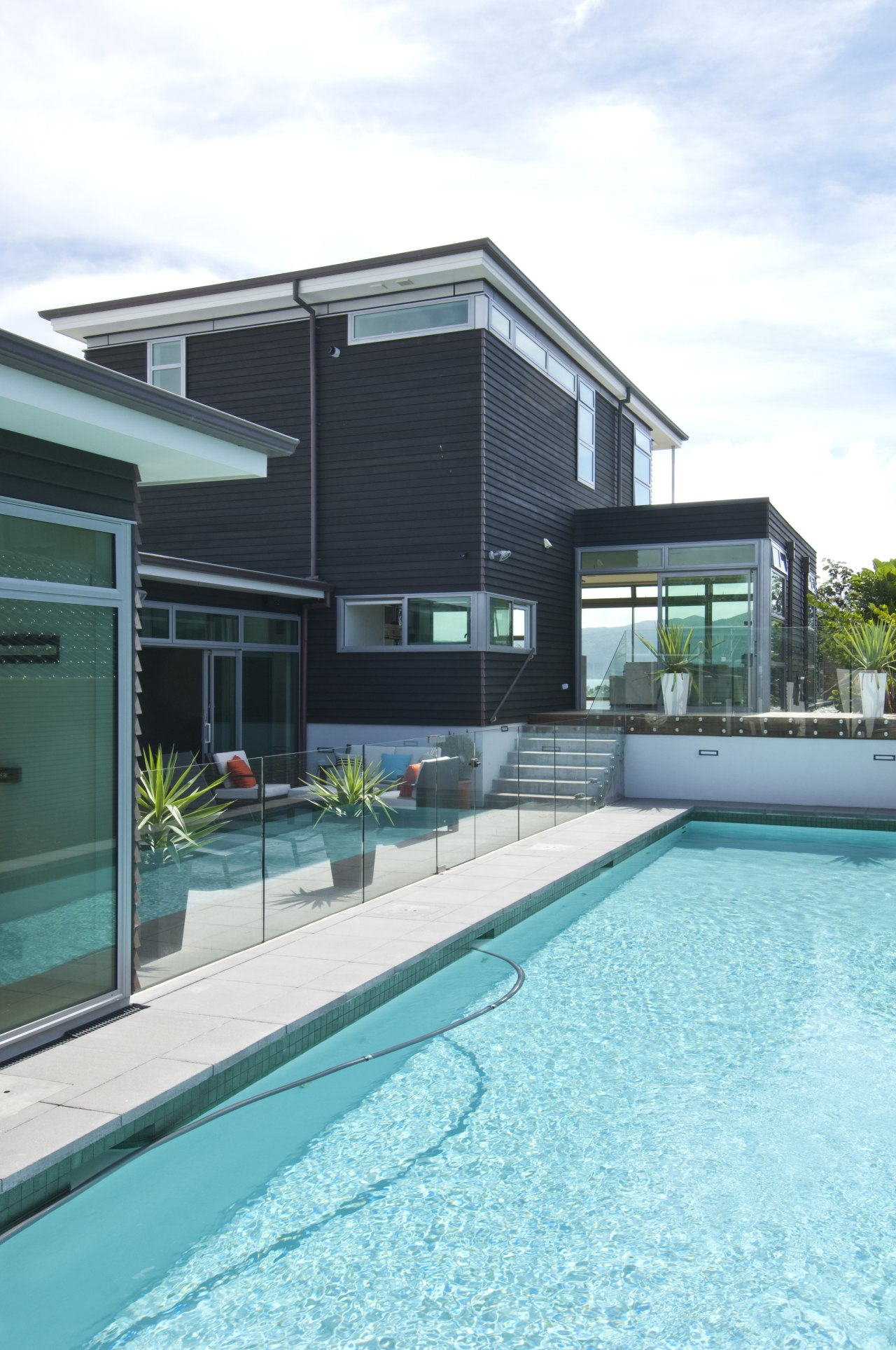 Poolside view of the contemporary home. architecture, estate, facade, home, house, leisure, leisure centre, property, real estate, swimming pool, water, teal, white