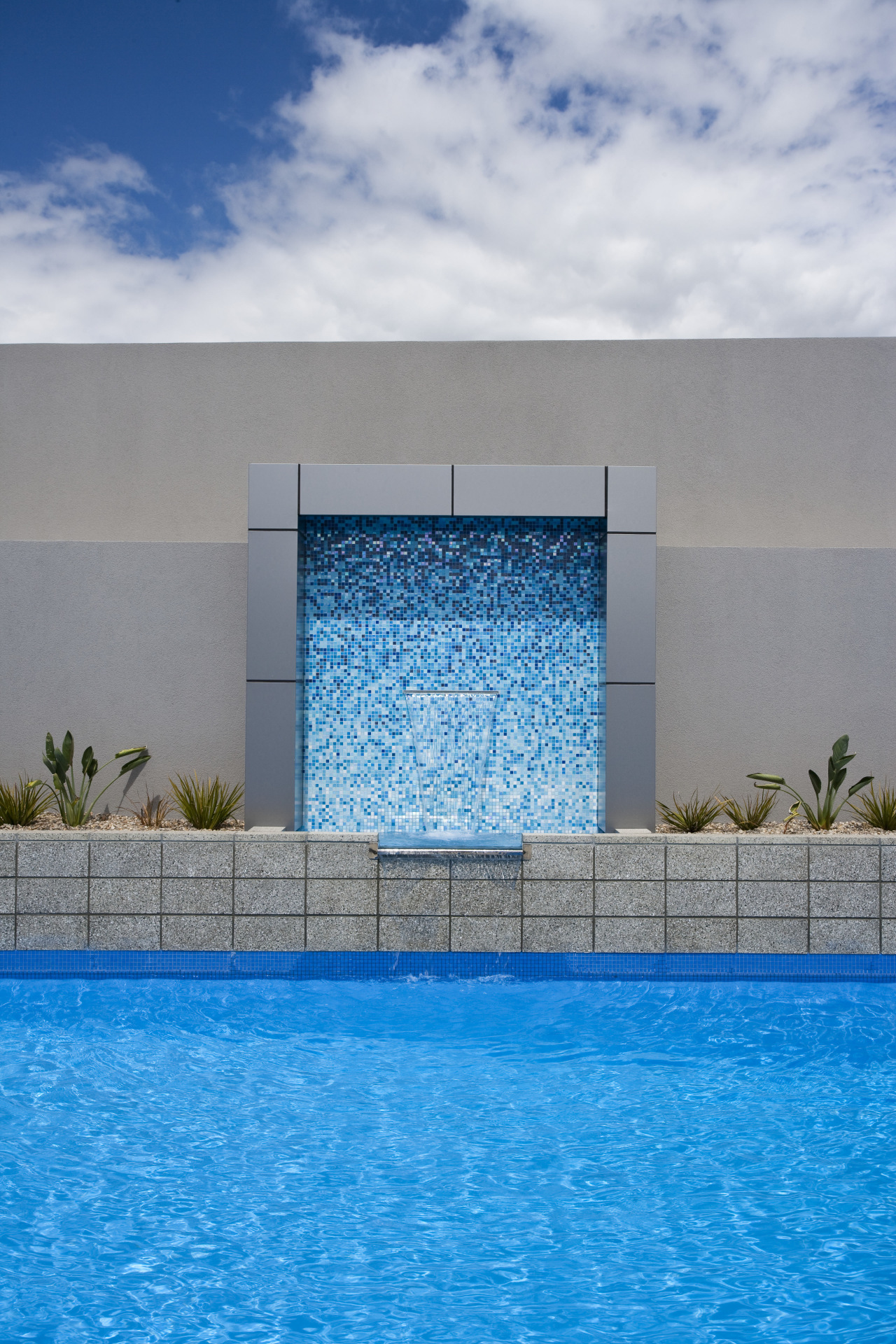 View of a paved pool area which features architecture, daytime, facade, house, property, real estate, sky, swimming pool, water, gray, teal