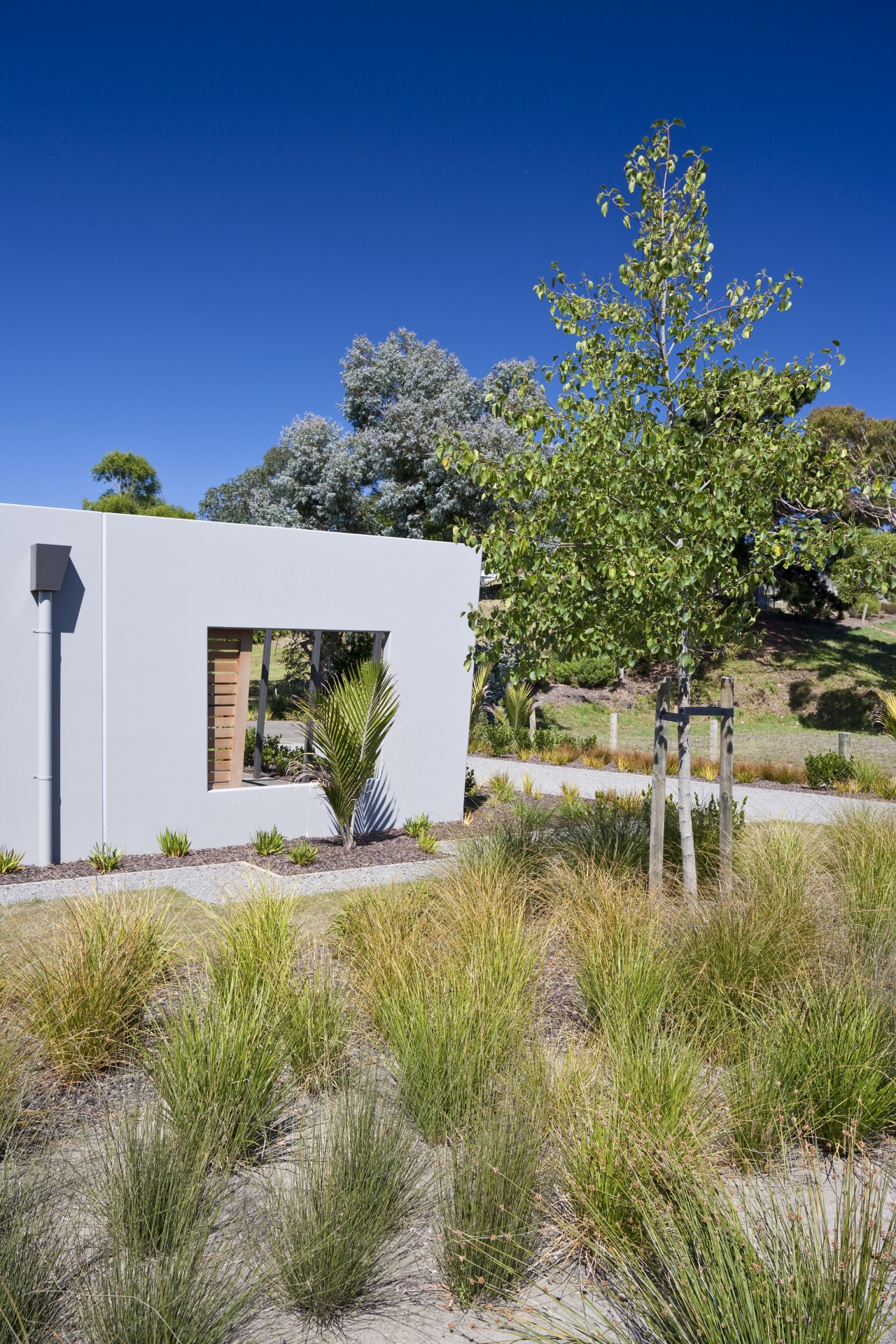 Exterior view of an energy-efficient home and gardens architecture, cottage, estate, grass, home, house, land lot, landscape, landscaping, plant, property, real estate, sky, tree, yard, brown, blue