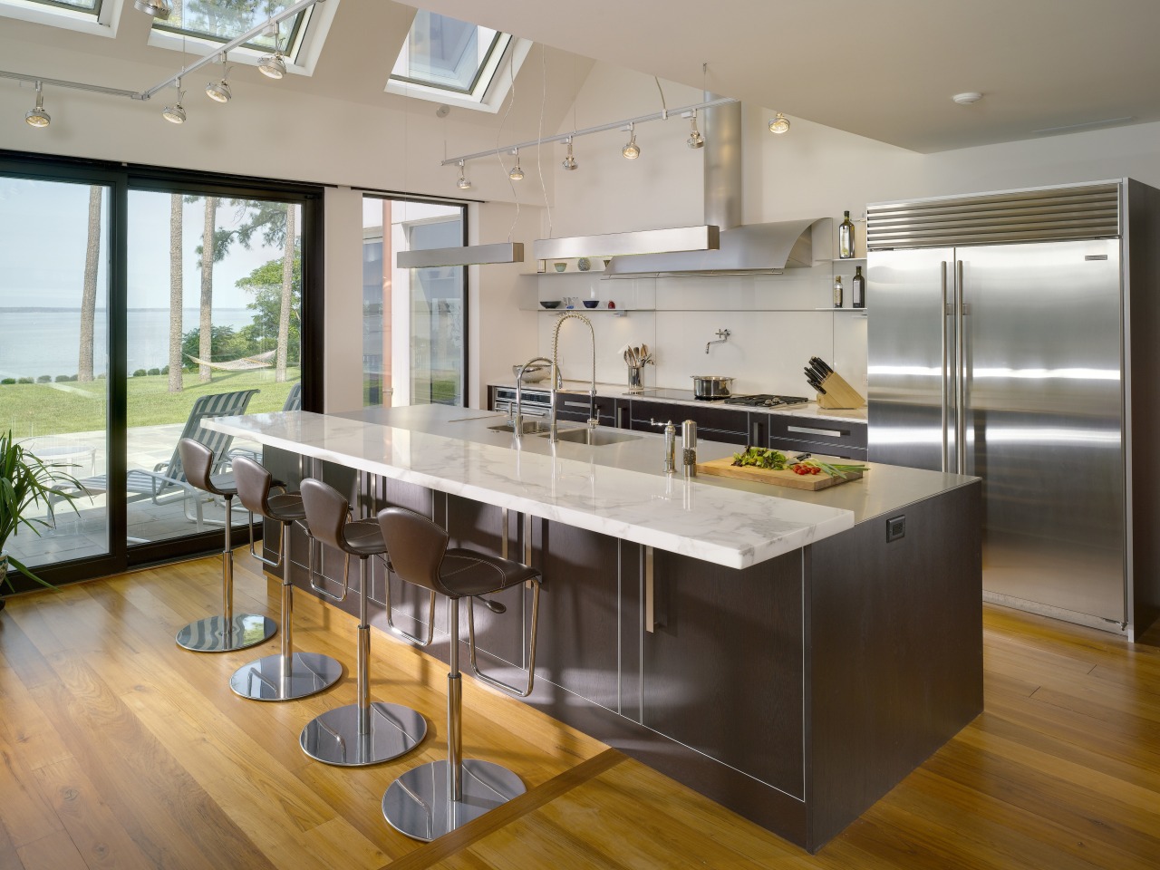 View of contemporary kitchen which features island, stainless countertop, interior design, kitchen, real estate, gray, brown