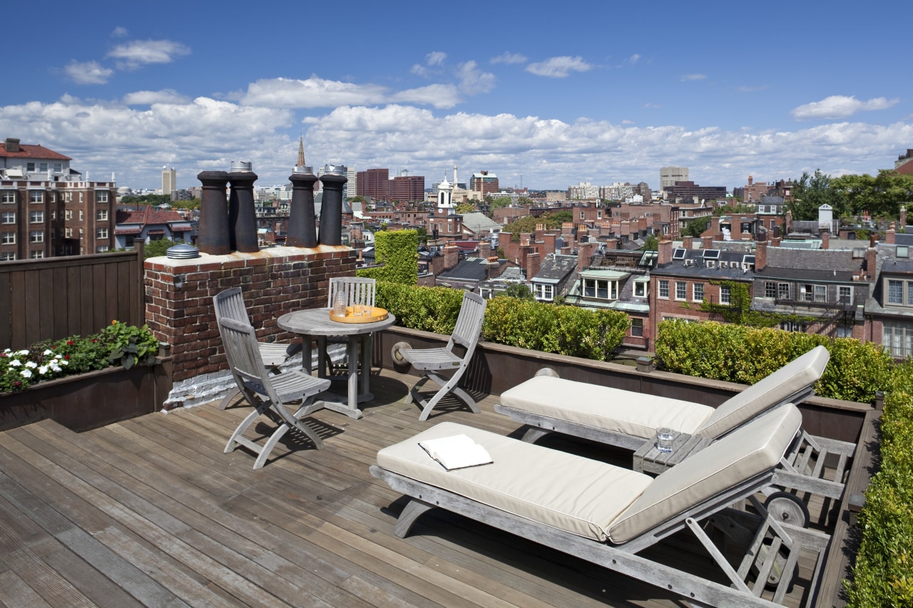 Exterior view of this contemporary home remodeled by apartment, balcony, city, condominium, home, outdoor structure, property, real estate, residential area, roof, gray