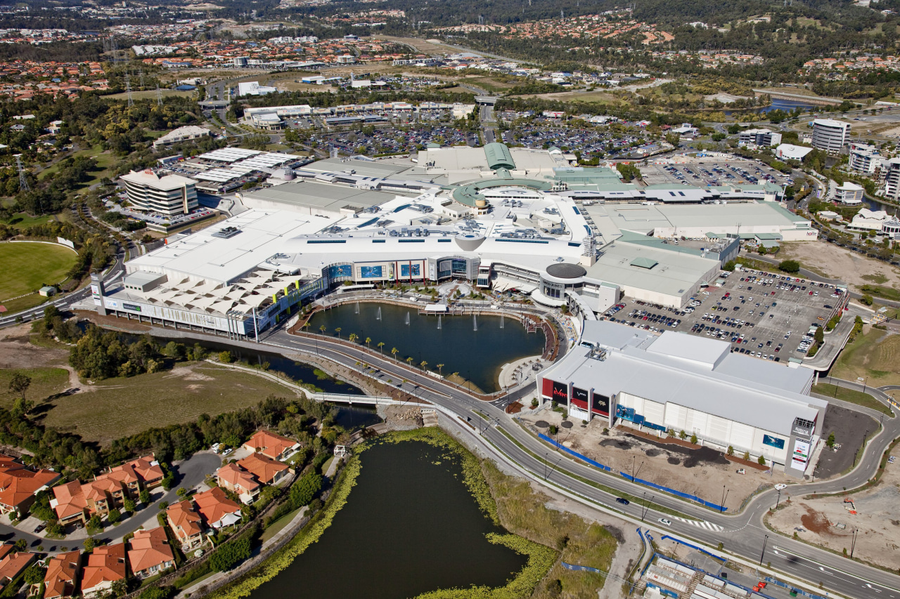 Exterior view of the Robina Town Centre where aerial photography, bird's eye view, city, metropolitan area, photography, real estate, residential area, suburb, urban area, urban design, water, waterway, gray, brown
