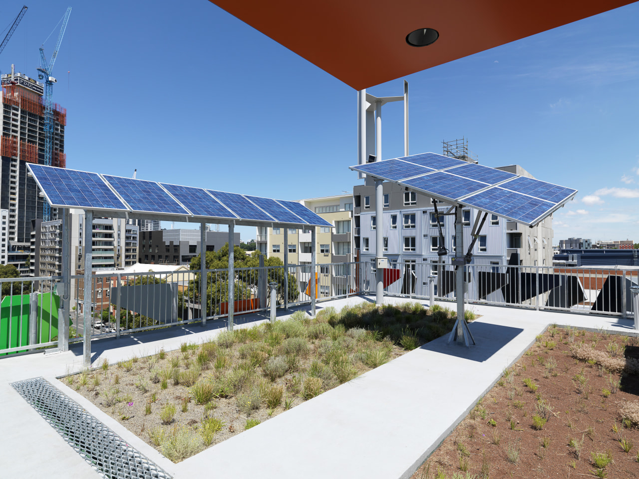 View of photovoltaic solar system on roof of apartment, condominium, home, mixed use, property, real estate, roof, sky, water, teal