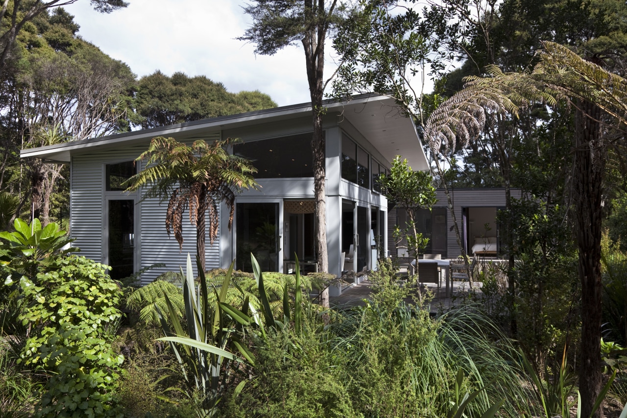 View of contemporary home surrounded by trees. cottage, estate, home, house, plant, property, real estate, tree, villa, black, brown