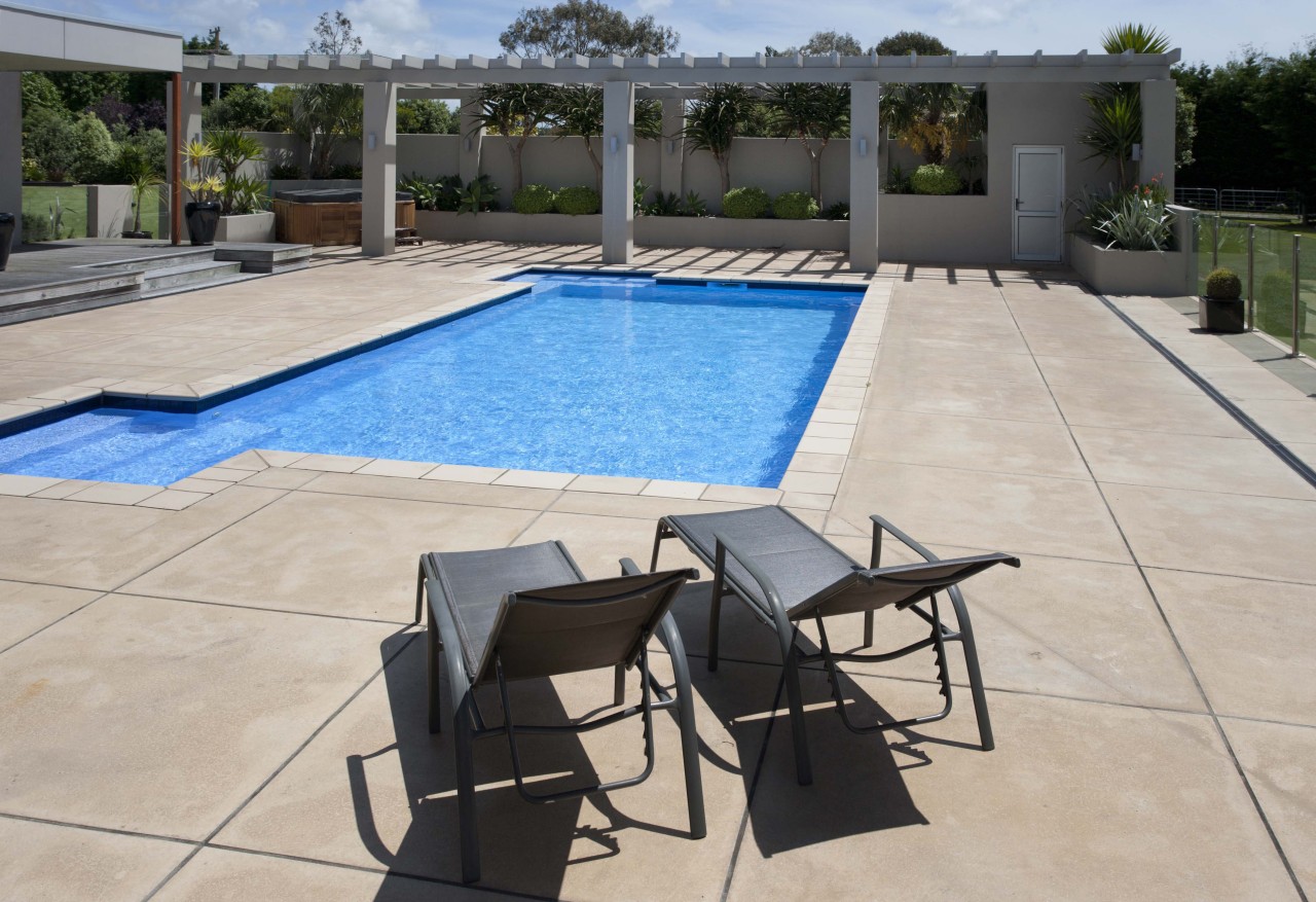 Here is a view of the Pisa Blue backyard, chair, floor, flooring, leisure, outdoor furniture, outdoor structure, patio, property, real estate, sunlounger, swimming pool, table, gray