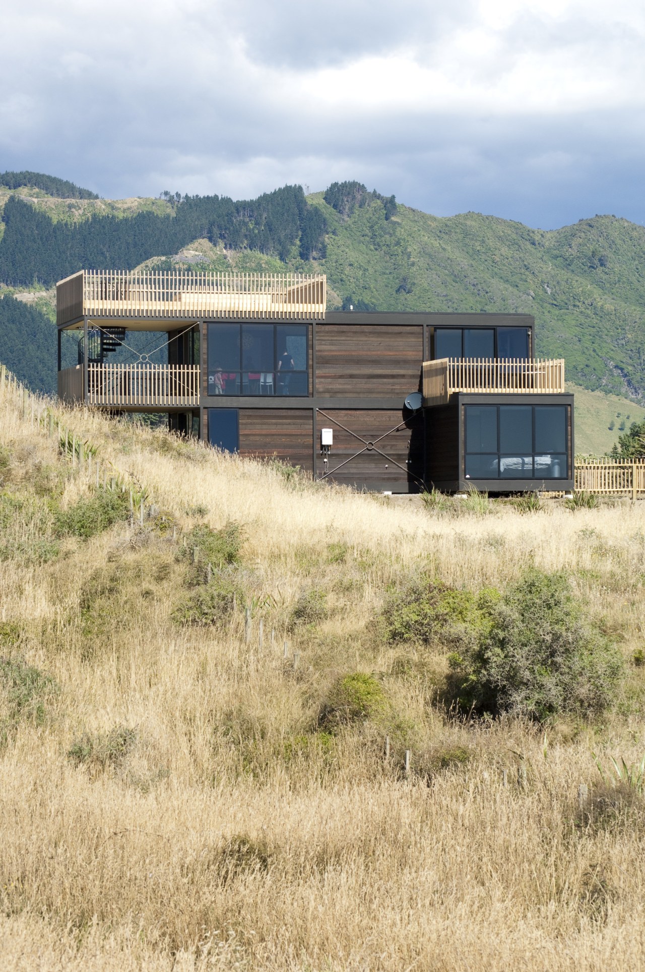 View of contemporary home on tussocky slope. architecture, home, house, land lot, landscape, prairie, property, real estate, rural area, shack, shed, sky, orange