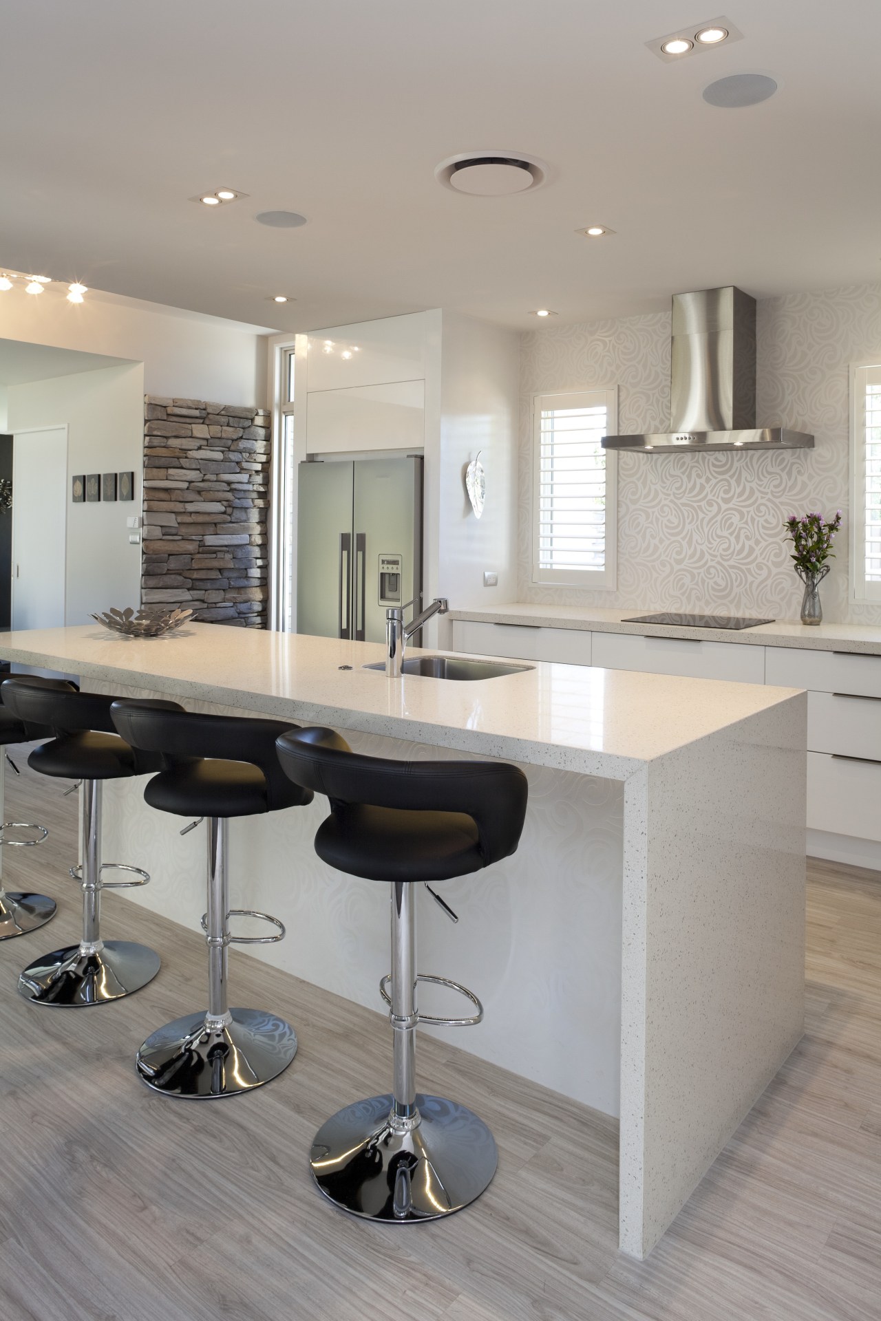 Kitchen with white island, white cabinetry, stainless hood countertop, floor, flooring, furniture, interior design, kitchen, product design, table, gray