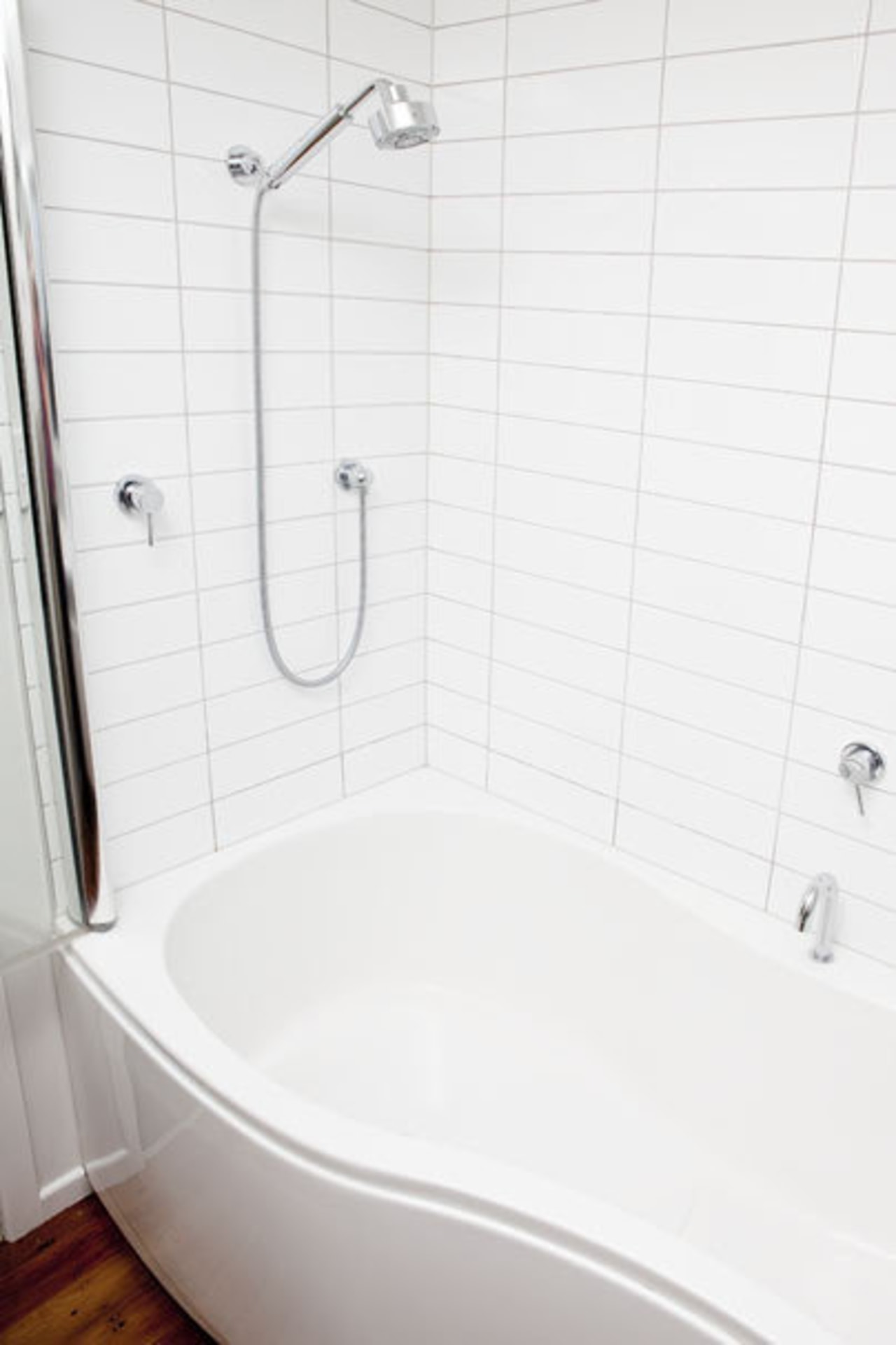 White tiled bathroom with white bath. angle, bathroom, bathroom sink, bathtub, floor, plumbing fixture, product, product design, room, tap, tile, toilet seat, wall, white