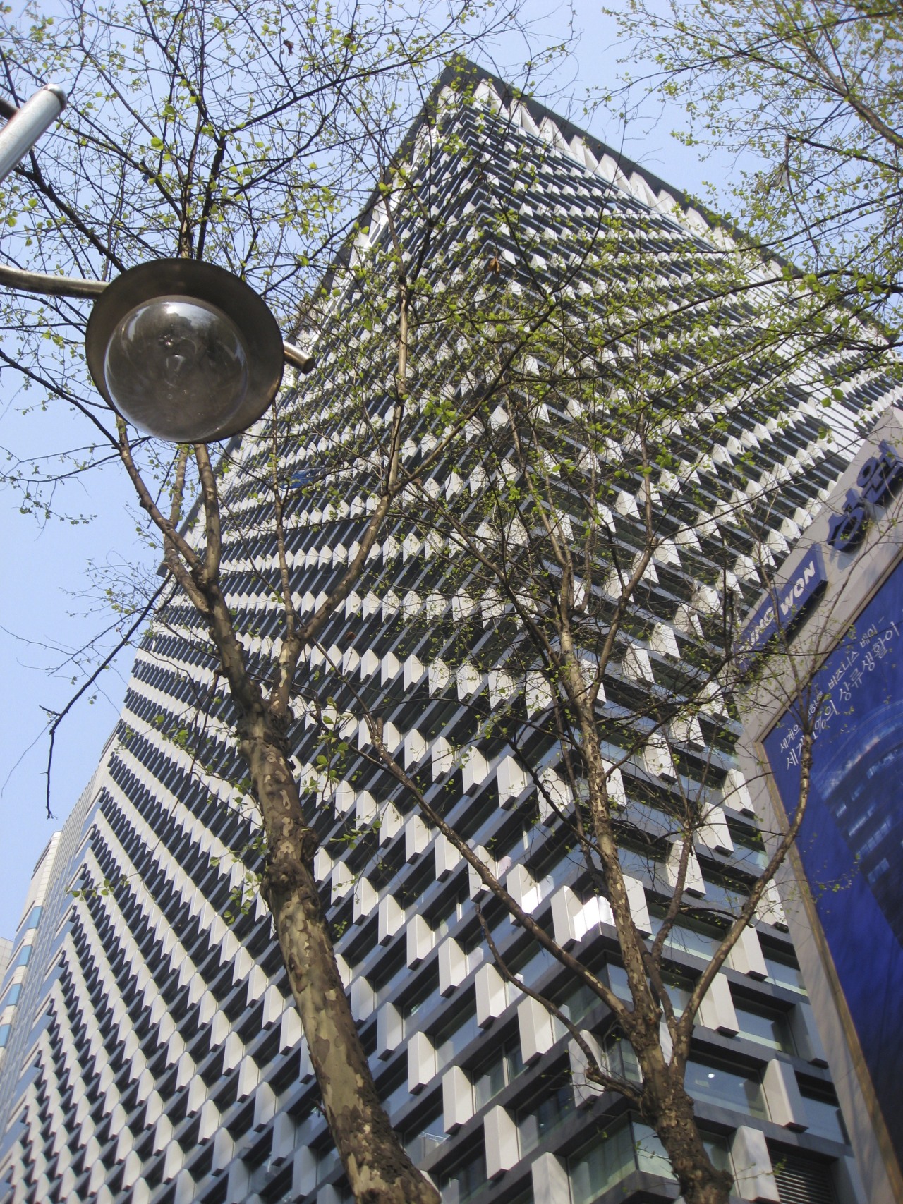 Low angle shot of office building. architecture, building, facade, outdoor structure, roof, tree, black
