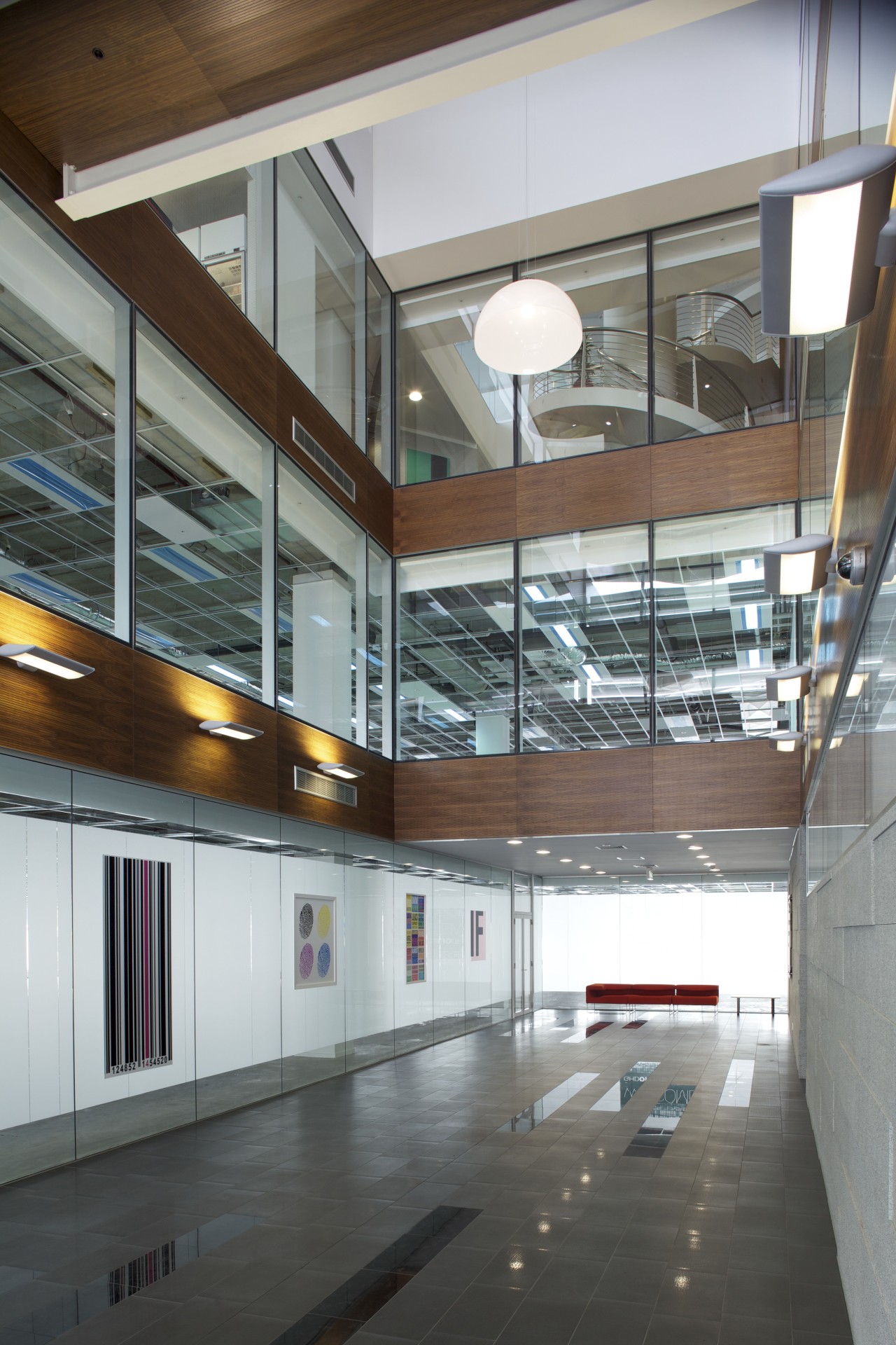 A large glass-walled atrium provides transparency at the architecture, building, ceiling, daylighting, glass, lobby, gray