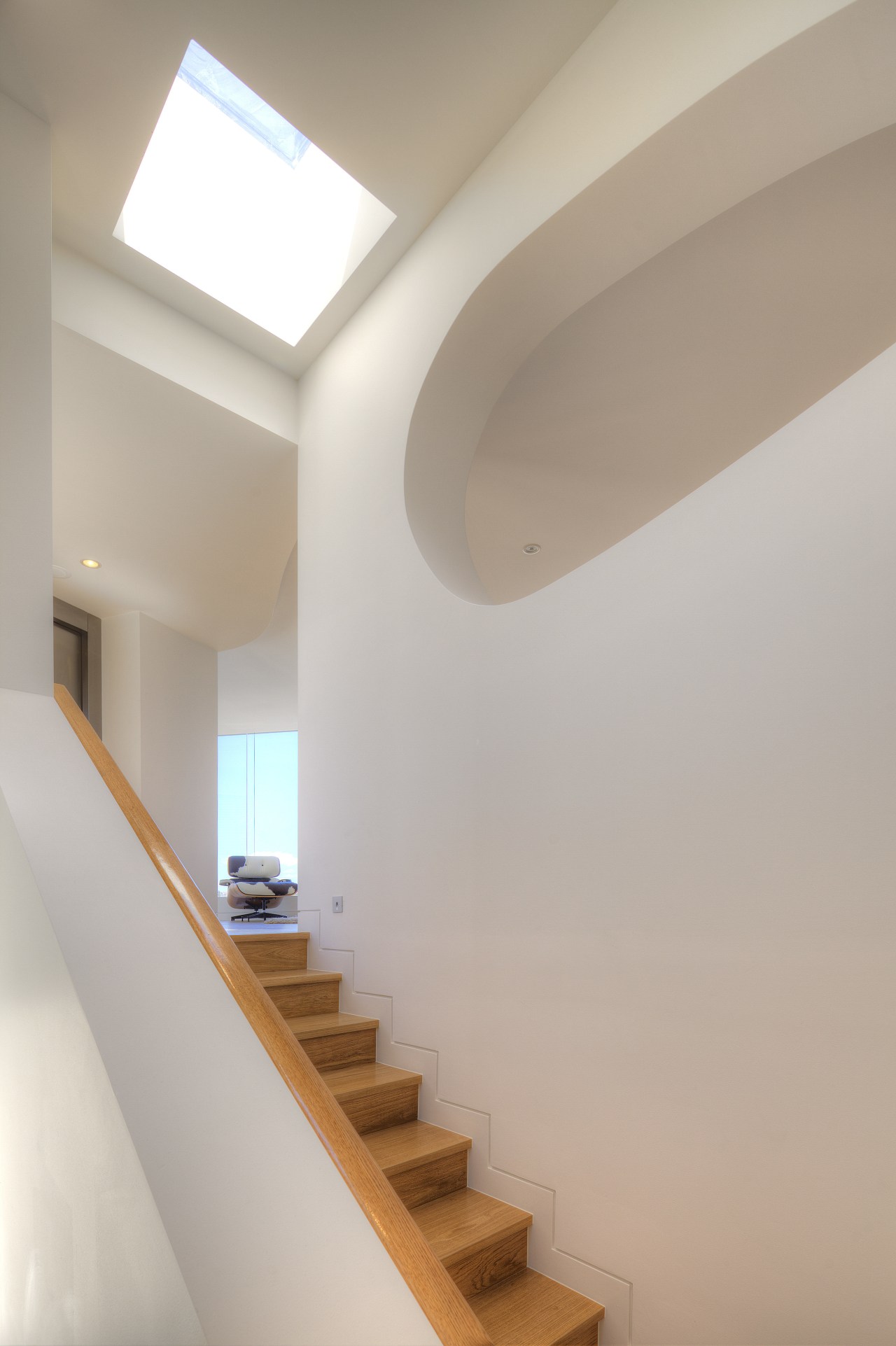 The distinctive shape of a cutout in the architecture, ceiling, daylighting, handrail, home, house, interior design, light, product design, property, stairs, wall, gray