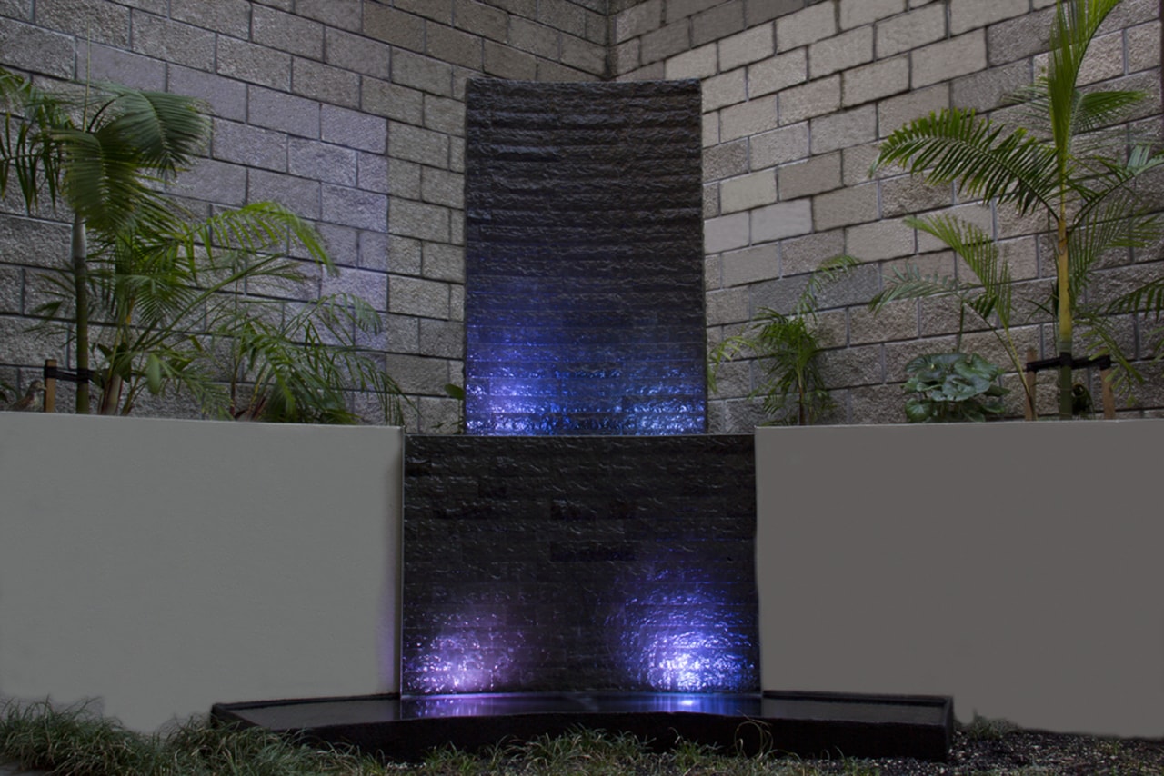 This water feature at night turns a bland, light, reflection, wall, gray, black