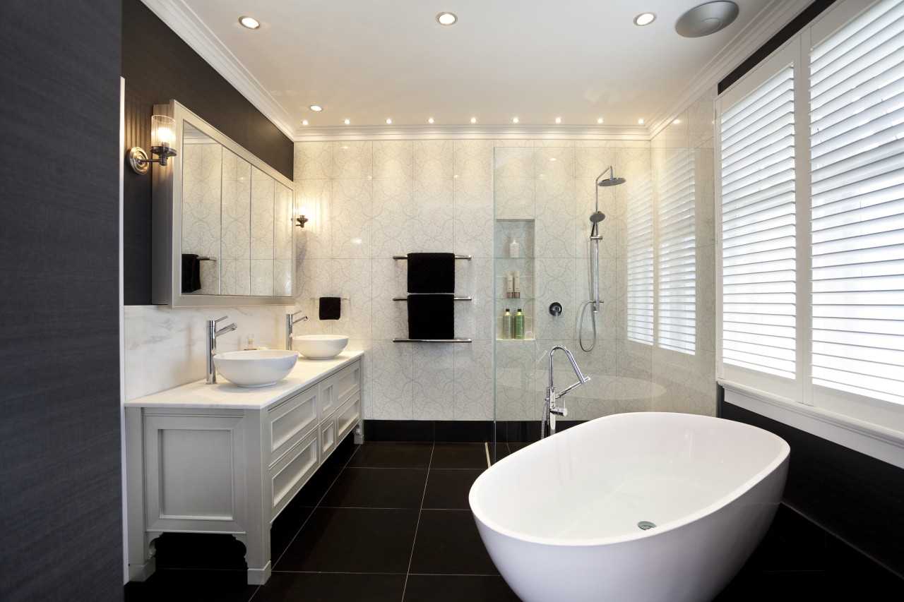 In this master bathroom, walls feature large tiles bathroom, home, interior design, property, real estate, room, sink, window, white, black