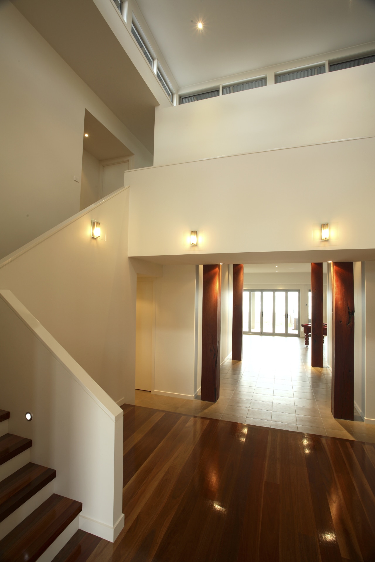 The interior reflects strong attention to detail that apartment, architecture, ceiling, daylighting, estate, floor, flooring, hall, handrail, hardwood, home, house, interior design, laminate flooring, lighting, lobby, loft, property, real estate, stairs, wall, wood, wood flooring, brown, orange