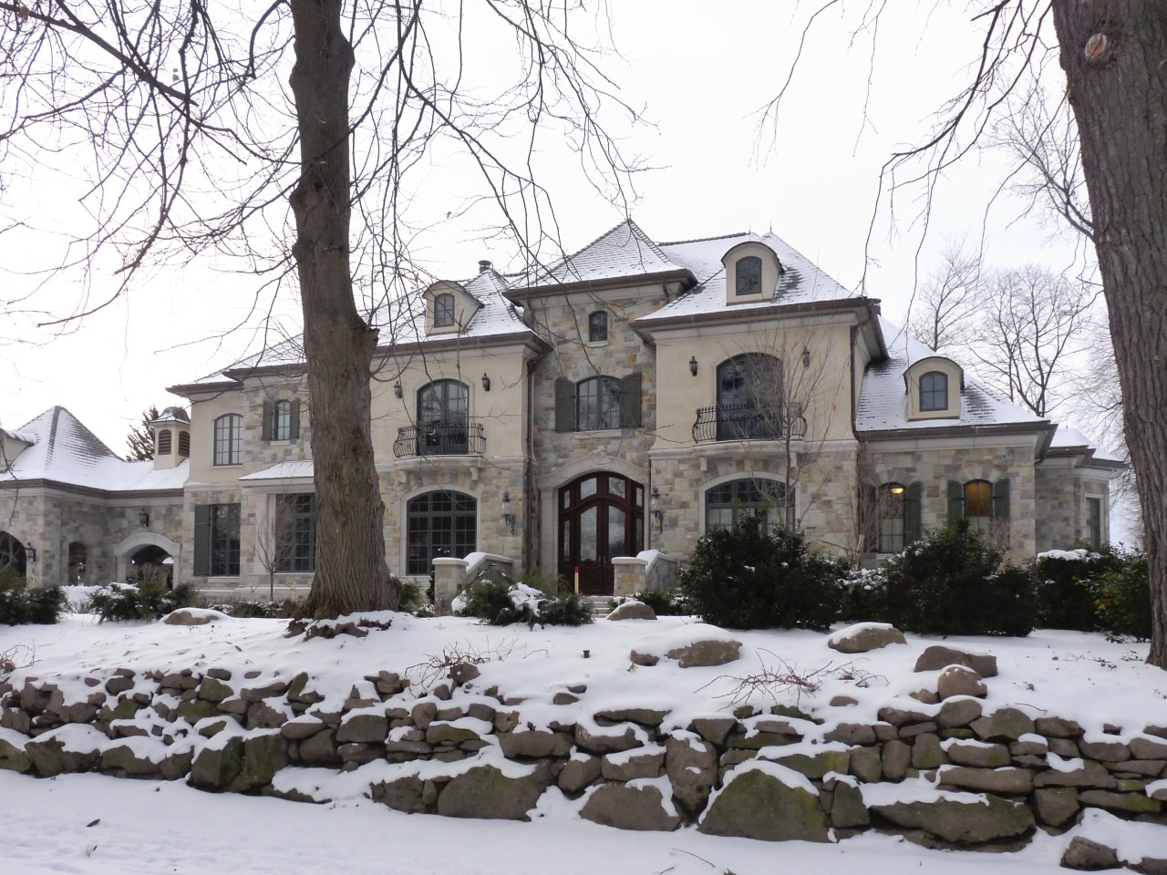 This home looks the part in a winter building, estate, facade, historic house, home, house, manor house, mansion, neighbourhood, property, real estate, residential area, snow, tree, window, winter, white, black