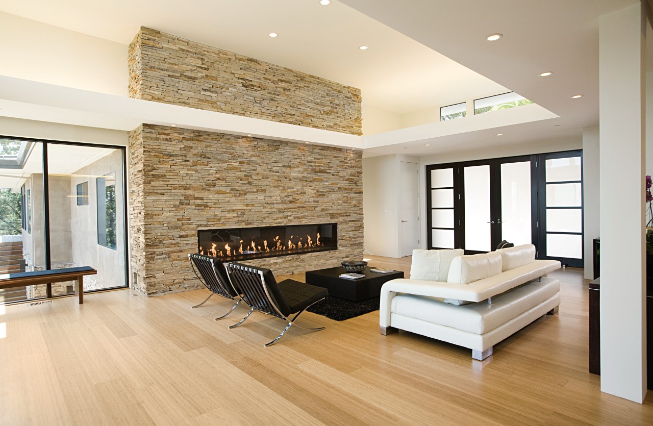 the natural stone wall appears to slice through ceiling, floor, flooring, hardwood, interior design, laminate flooring, living room, real estate, room, wall, wood, wood flooring, white