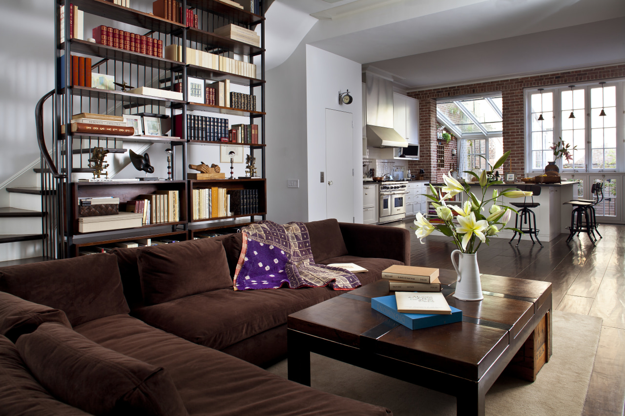 Stairs wind up behind the bookcase in this furniture, home, interior design, living room, room, gray