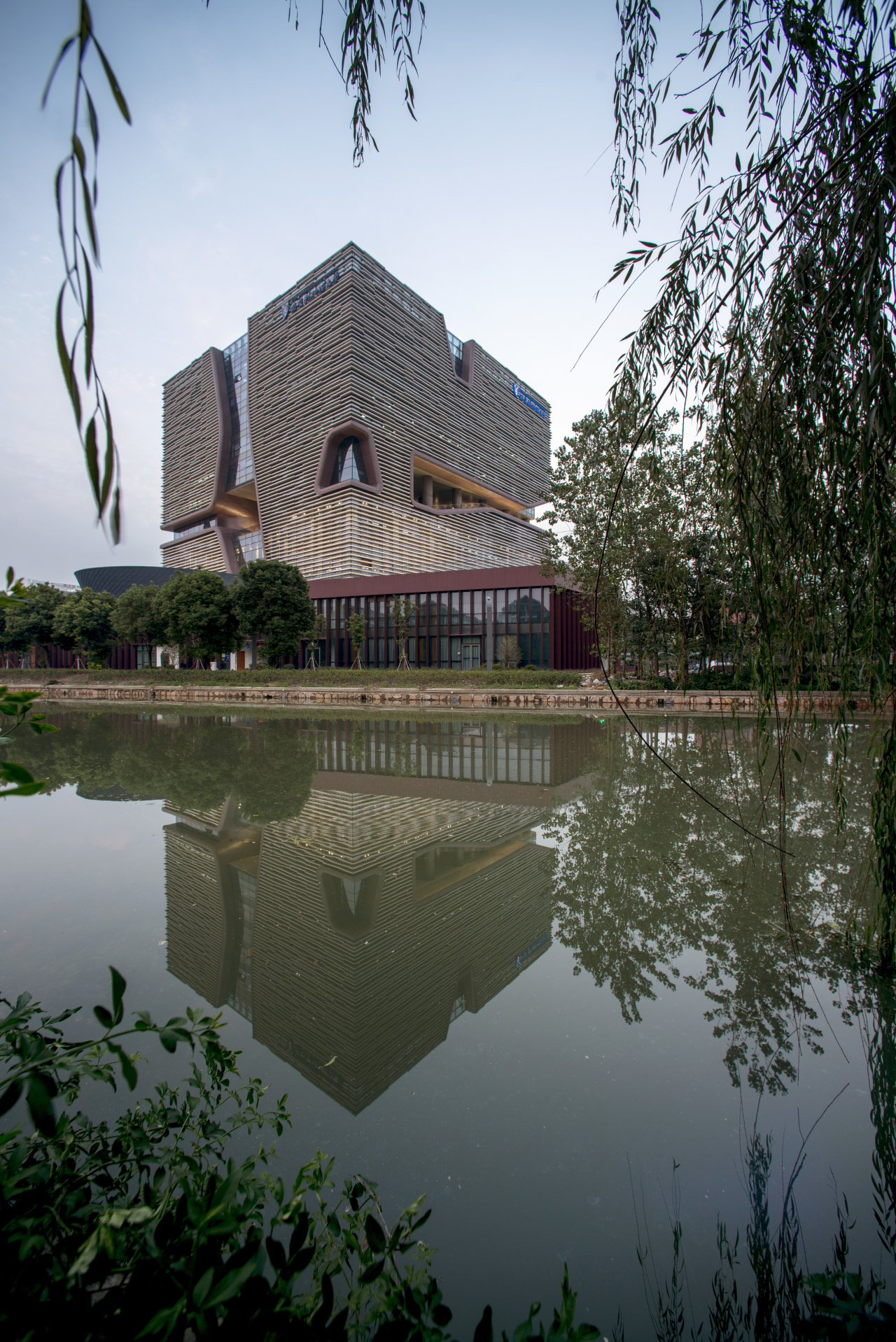 Set beside a meeting point of two key architecture, building, estate, home, house, plant, pond, real estate, reflection, sky, tourist attraction, tree, water