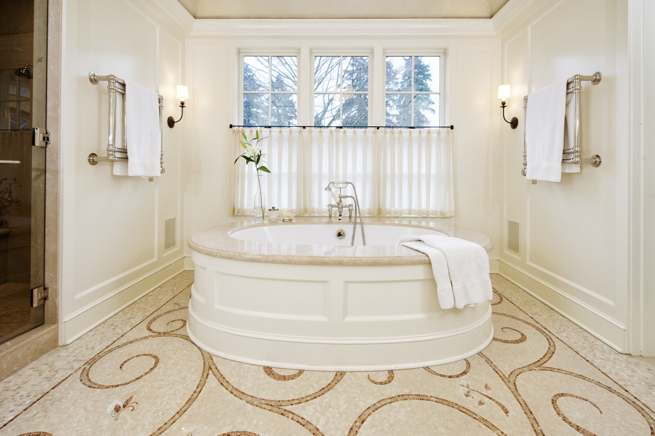 A large round tub with a marble surround bathroom, bathtub, estate, floor, flooring, home, interior design, plumbing fixture, property, real estate, room, tile, wall, window, wood flooring, white