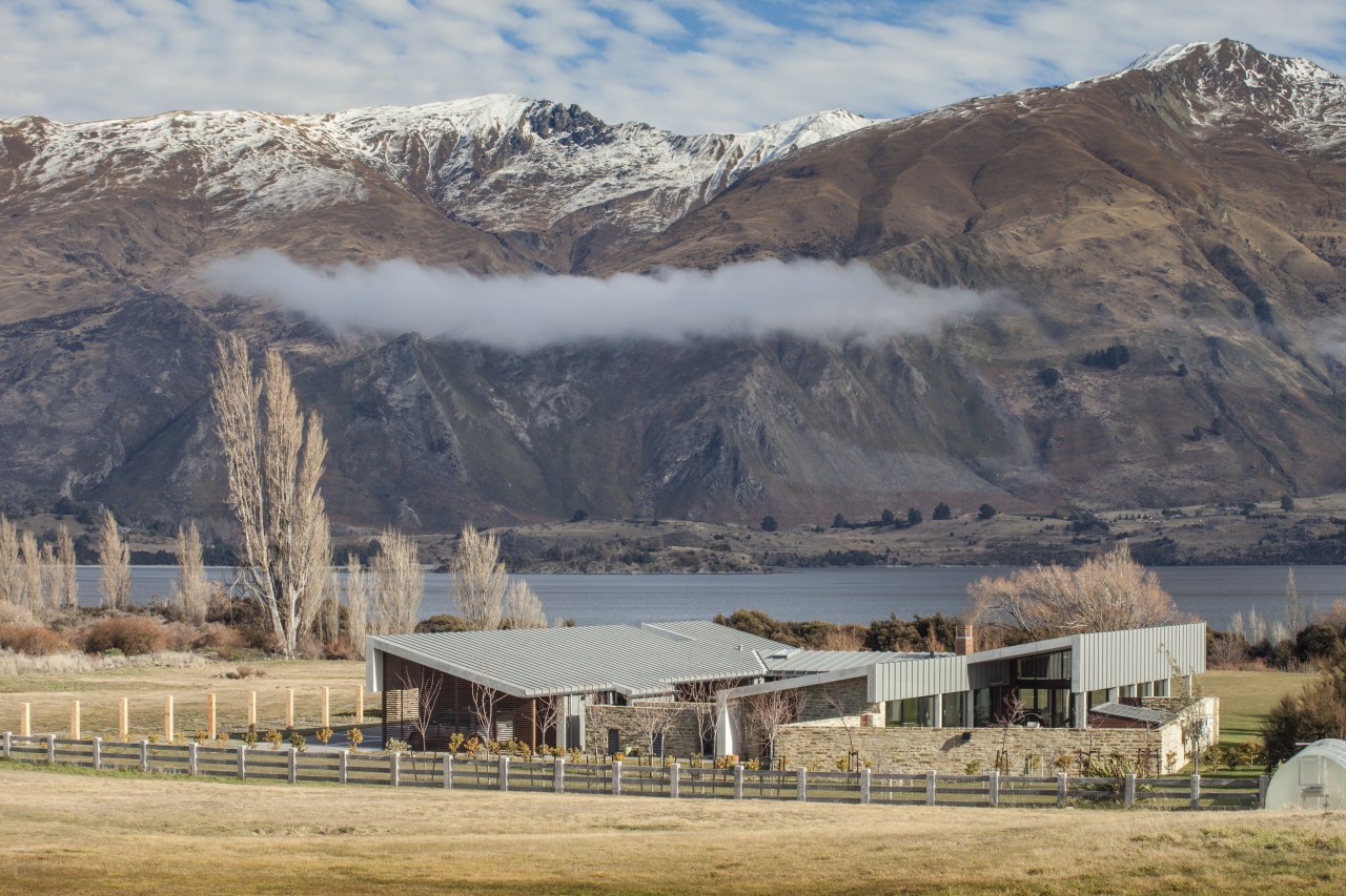 This large contemporary courtyard house nestles into the alps, cloud, elevation, fell, highland, hill, landscape, mountain, mountain range, mountainous landforms, national park, ranch, rural area, sky, snow, tree, wilderness, winter, gray