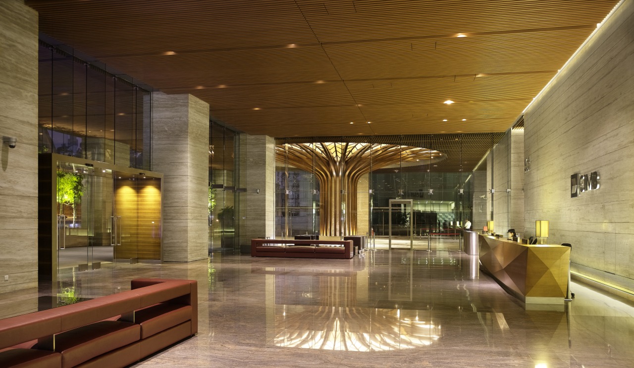 Bookmatched travertine marble walls line the lobby of architecture, ceiling, condominium, interior design, lighting, lobby, brown