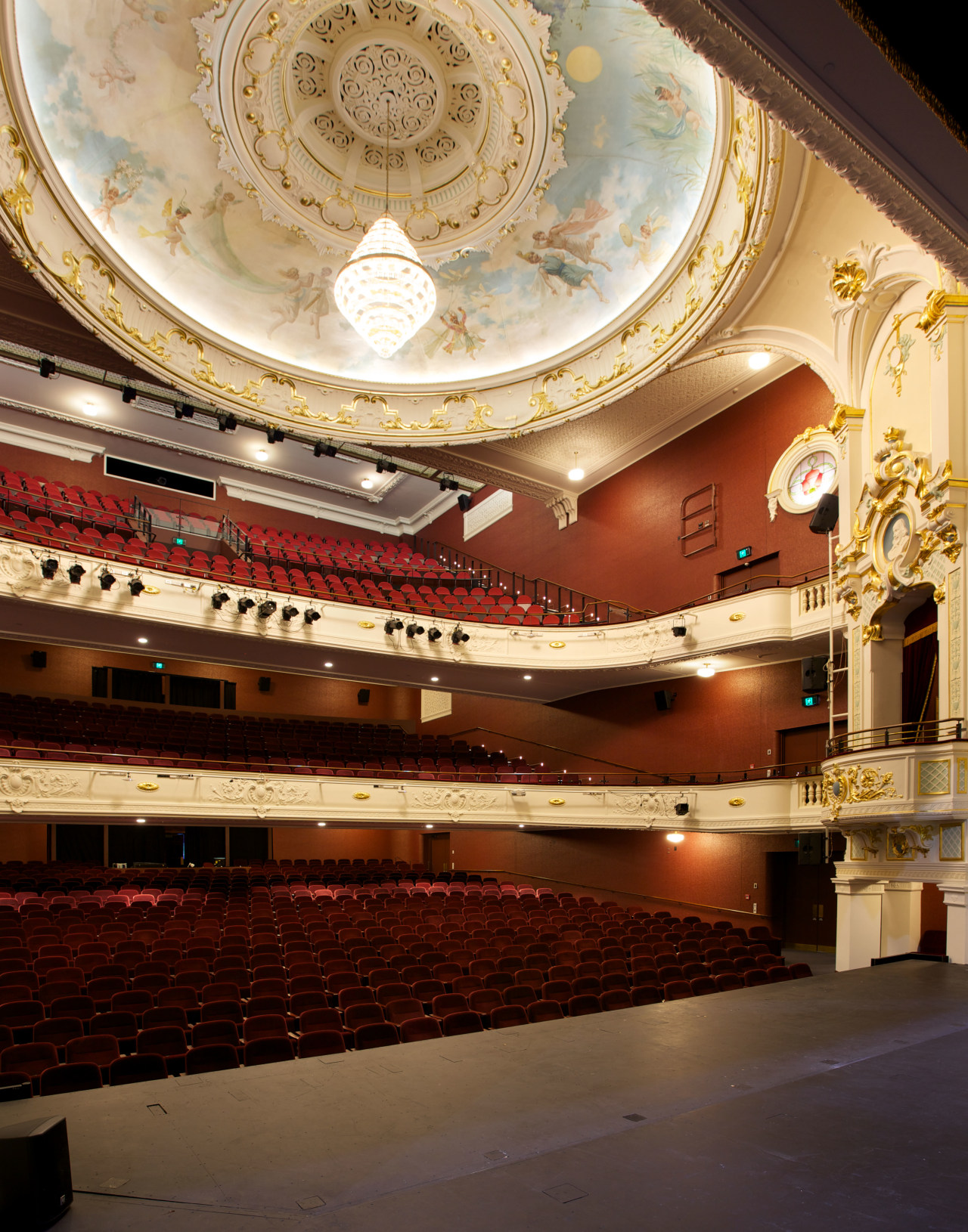 Custom chandeliers at the Isaac Theatre Royal were auditorium, ceiling, concert hall, opera house, performing arts center, theatre, orange, brown, red