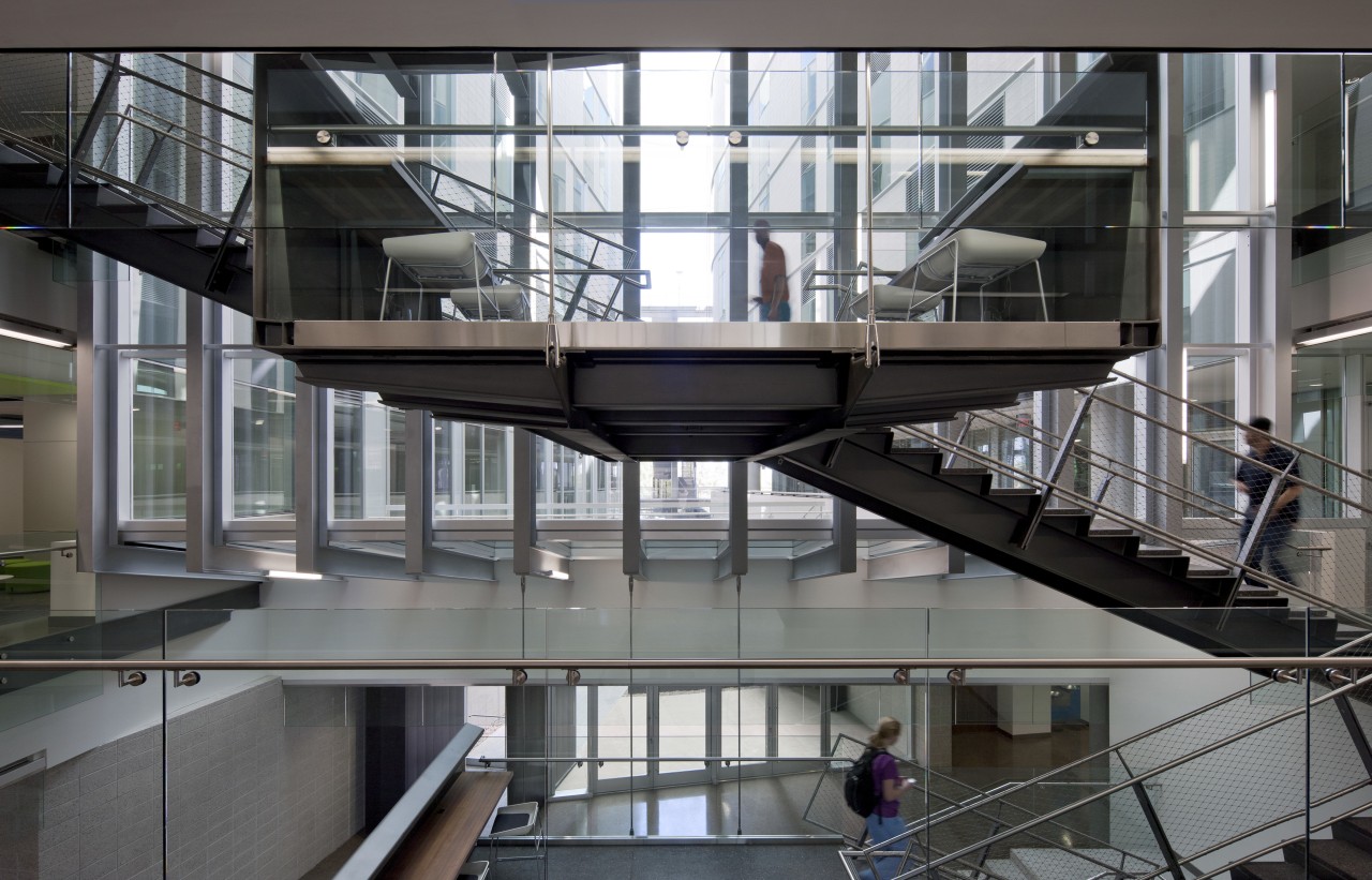 :The main circulation stair in this educational facility architecture, building, condominium, daylighting, glass, handrail, mixed use, stairs, structure, gray, black