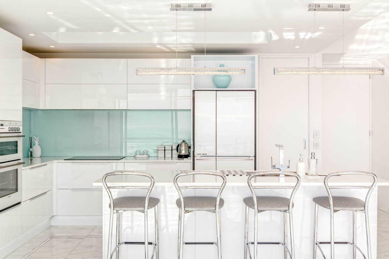 A green back-painted glass splashback complements the interiors furniture, interior design, kitchen, product design, table, white