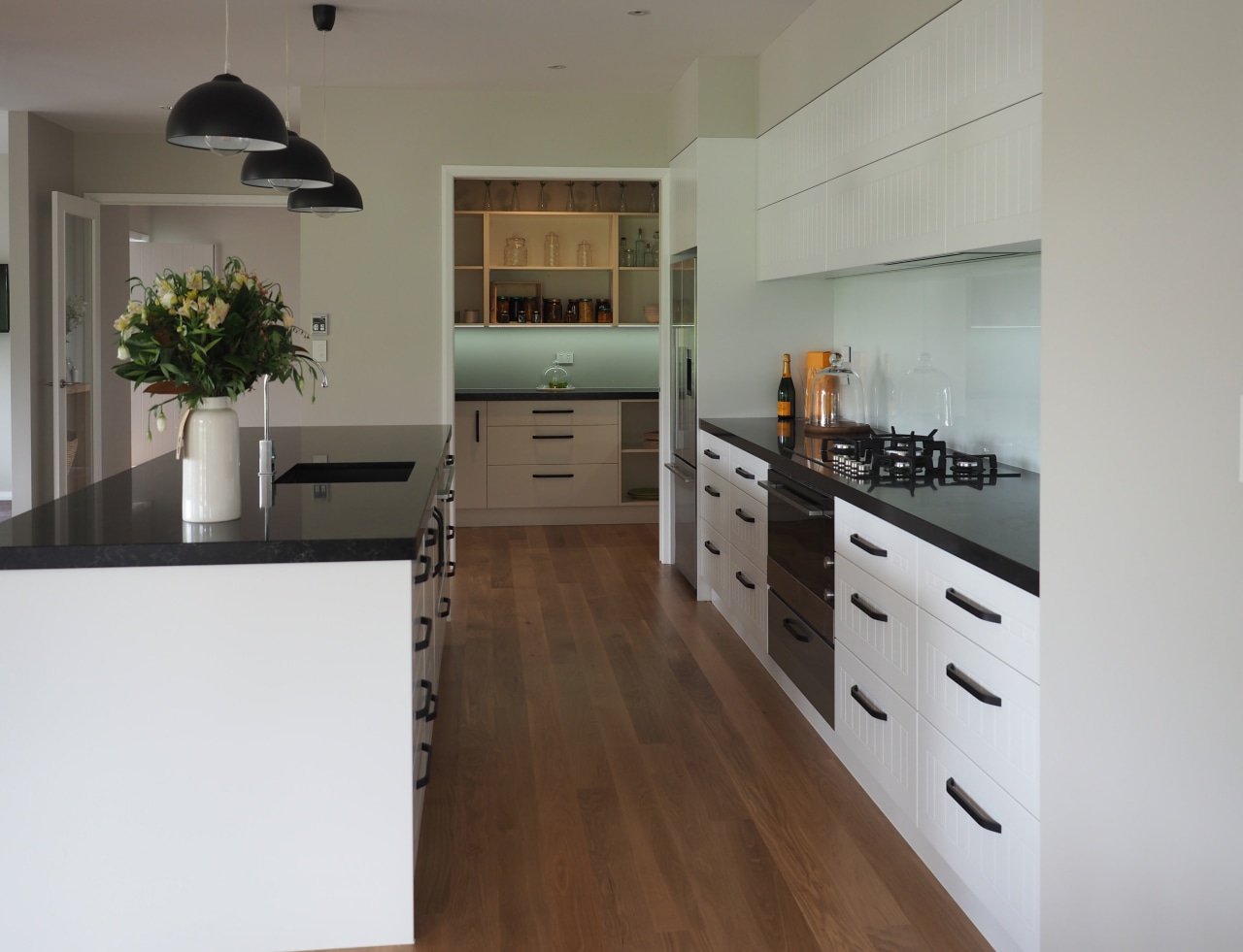 This modern kitchen in Landmark show home has cabinetry, countertop, cuisine classique, floor, flooring, hardwood, interior design, kitchen, room, wood flooring, gray