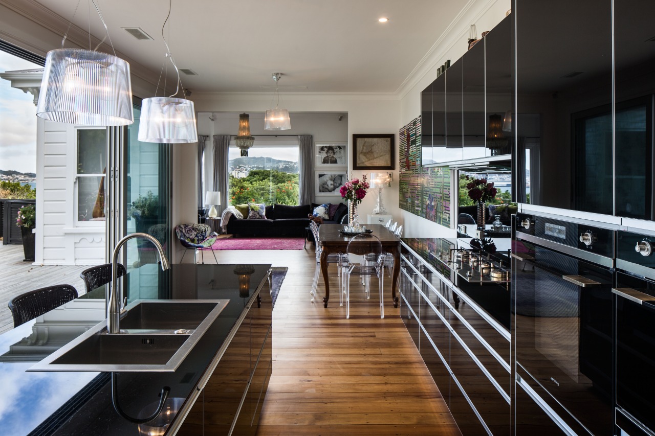 The black glass kitchen surfaces complement the transparent countertop, interior design, kitchen, real estate, black, gray