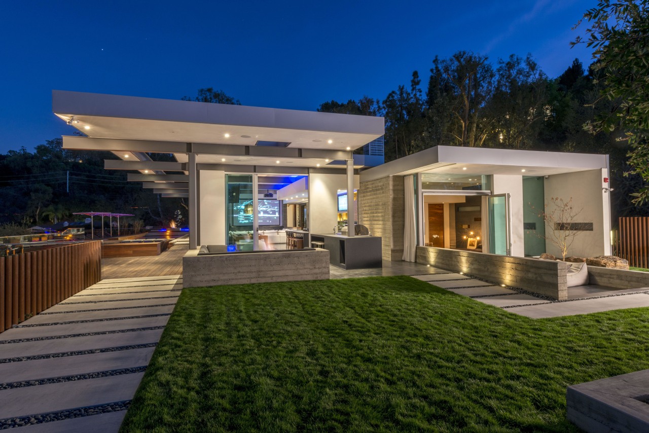 The board-formed concrete wall seen behind the barbecue architecture, backyard, elevation, estate, facade, home, house, lighting, property, real estate, residential area, roof, villa, brown