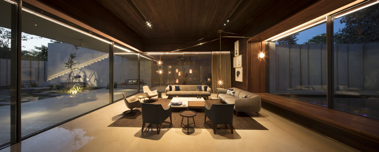 The dining area is situated in the longer architecture, building, ceiling, design, furniture, home, house, interior design, lighting, living room, property, real estate, room, black, brown