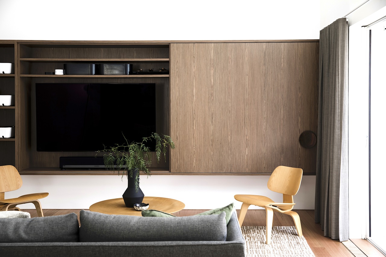 Bespoke walnut cabinetry offers handy living space functionality 