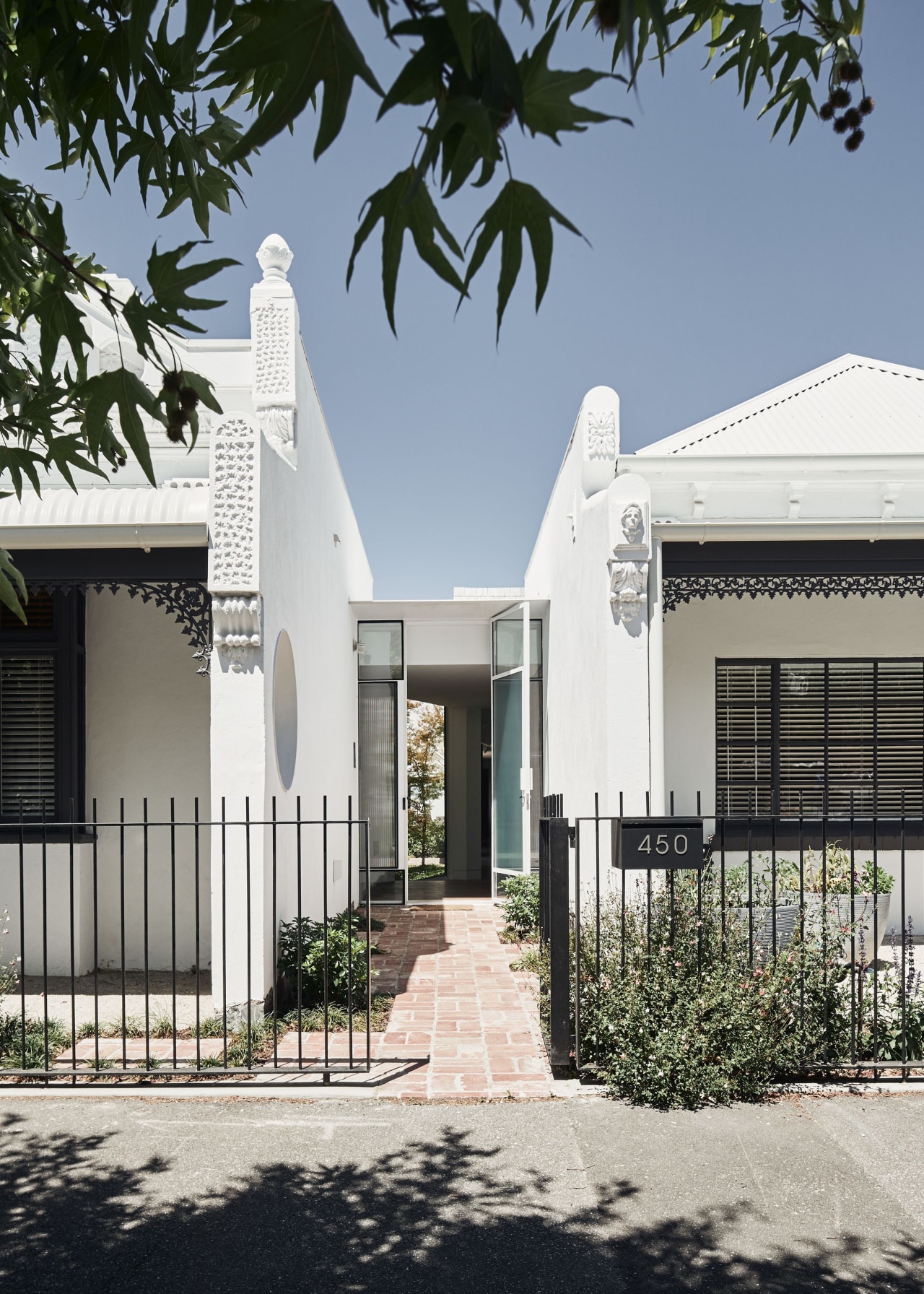 A glazed entry, set back between the heritage white